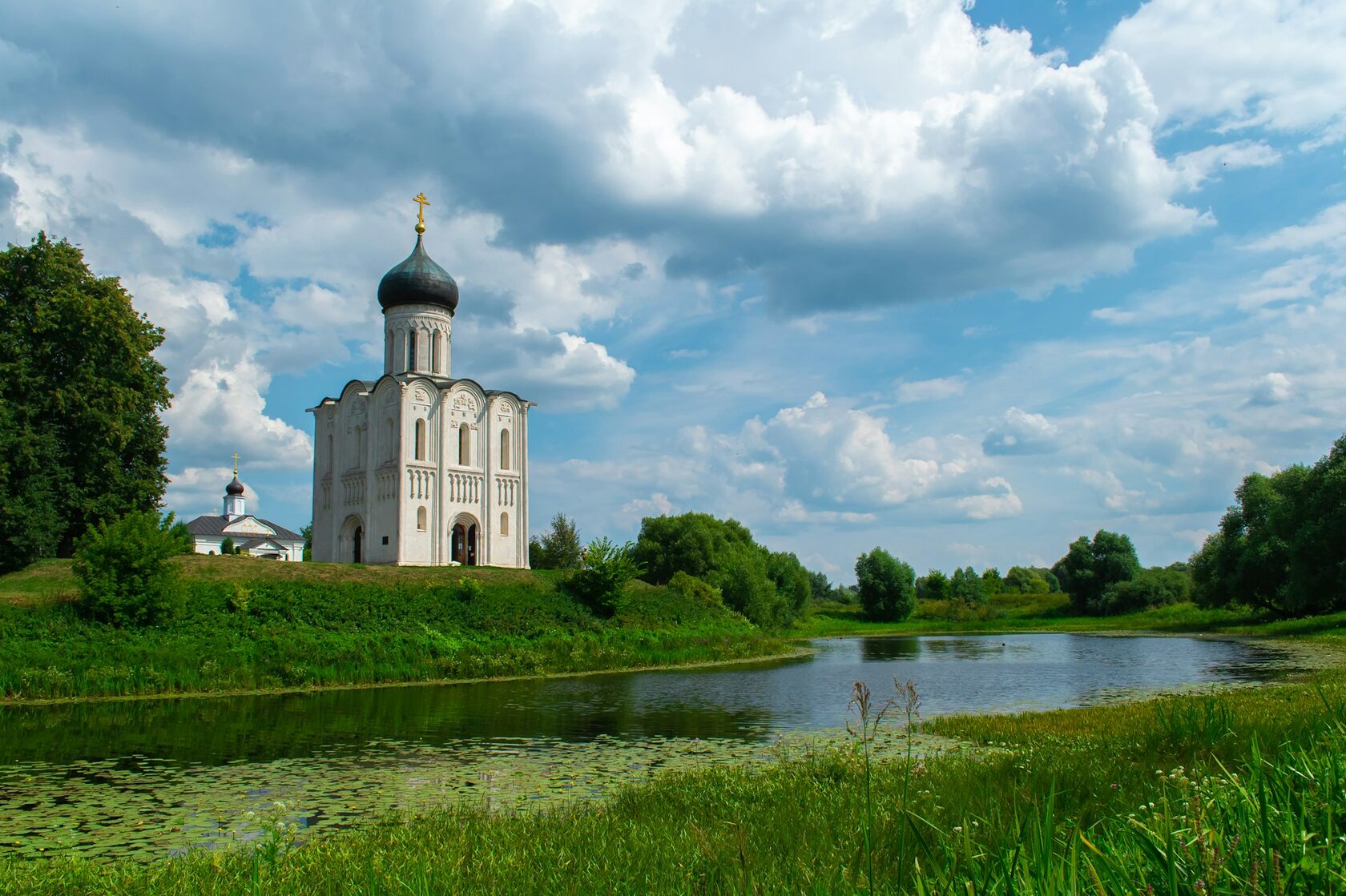 Paysage de la campagne russe en été, herbes hautes et petite chapelle au loin
