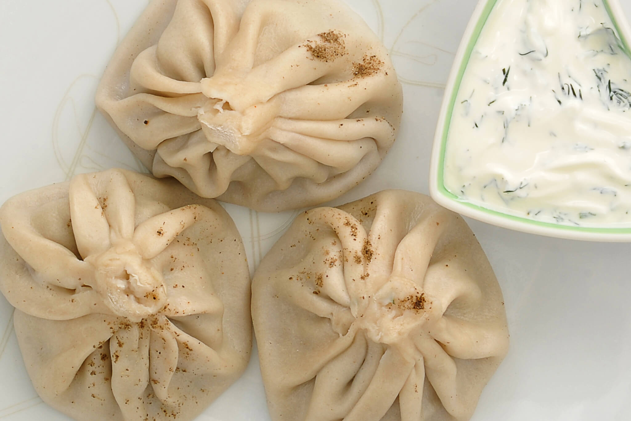 Georgian soup dumplings served with creamy sour cream sauce