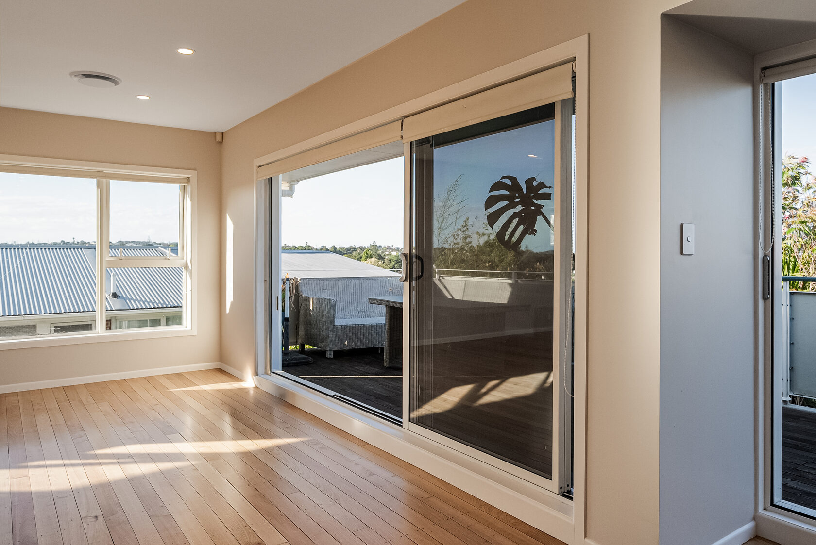 Bright Glenfield living area with wide glazing and direct access to the deck