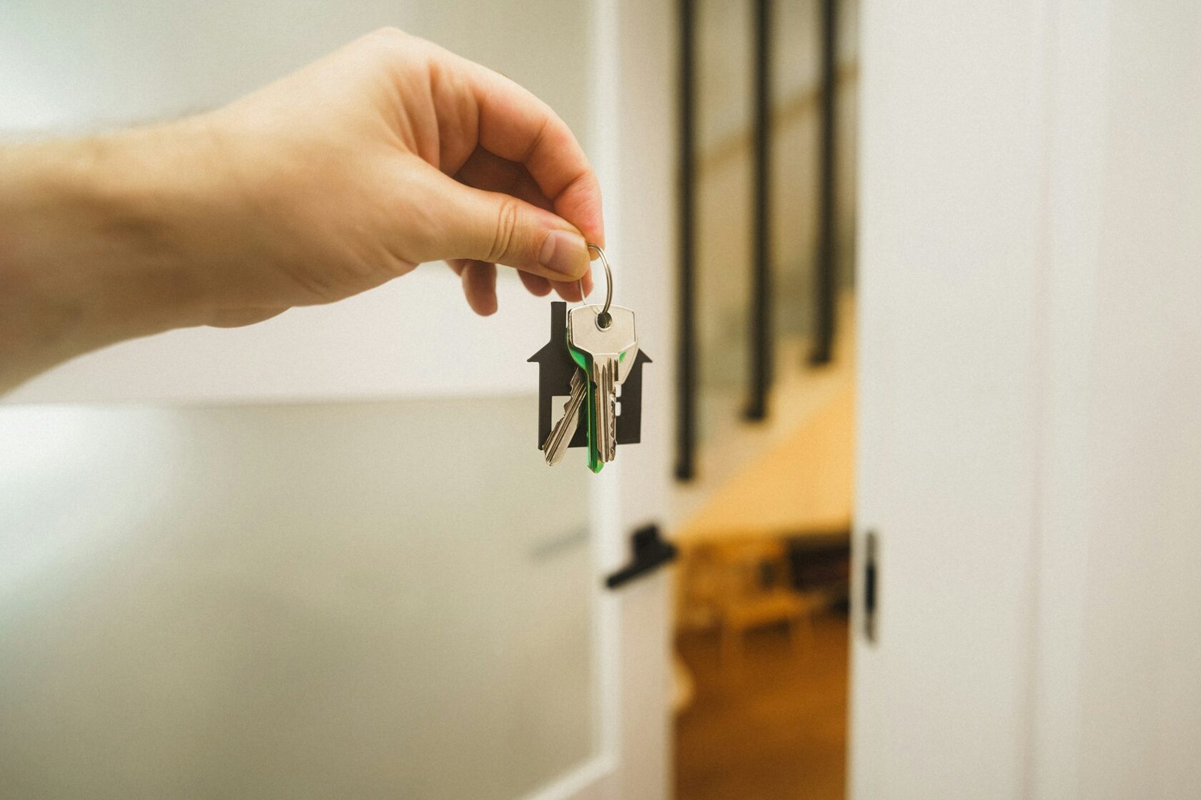 New homeowner holding keys to a freshly purchased house