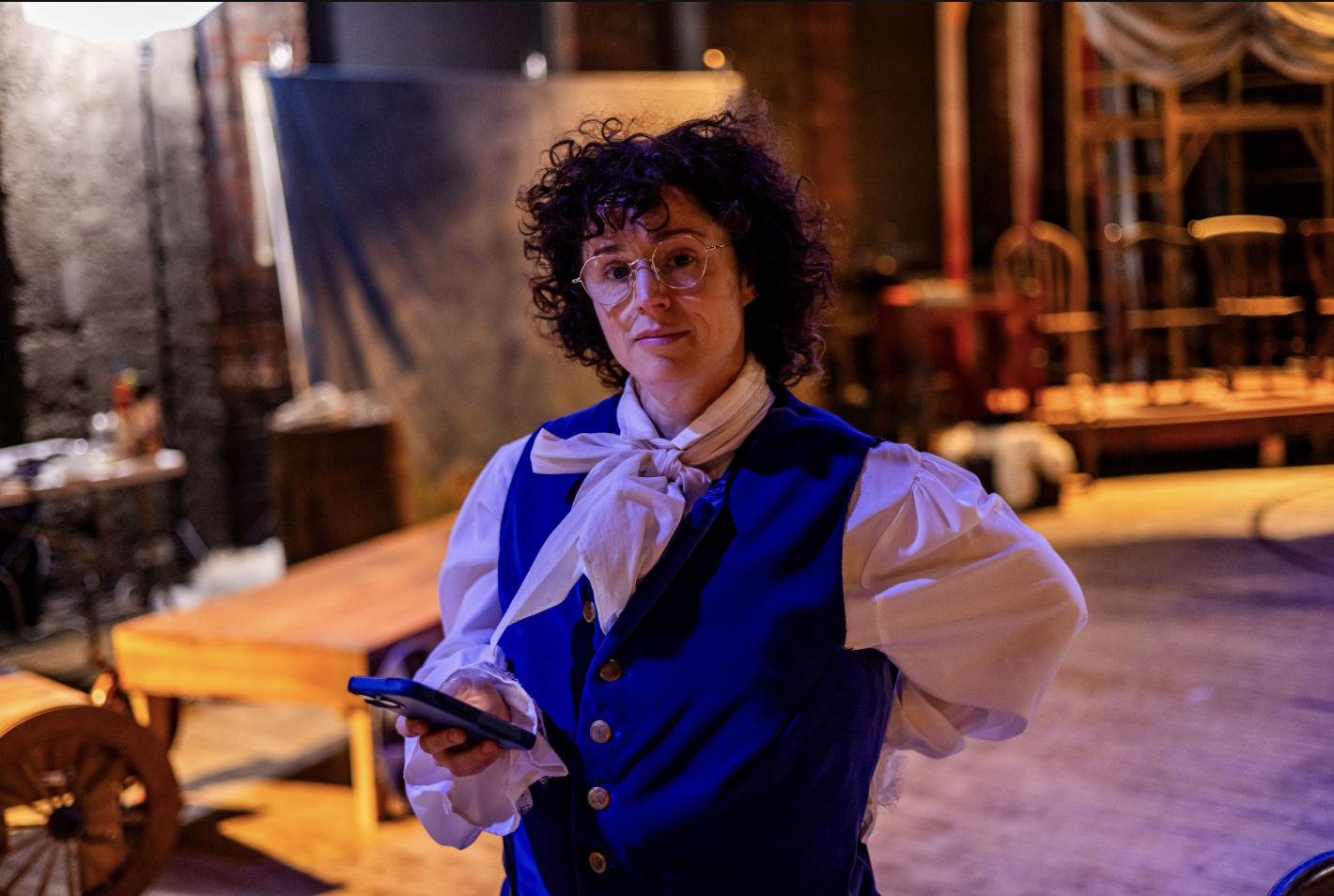Performer in a blue waistcoat in a theatrical setting