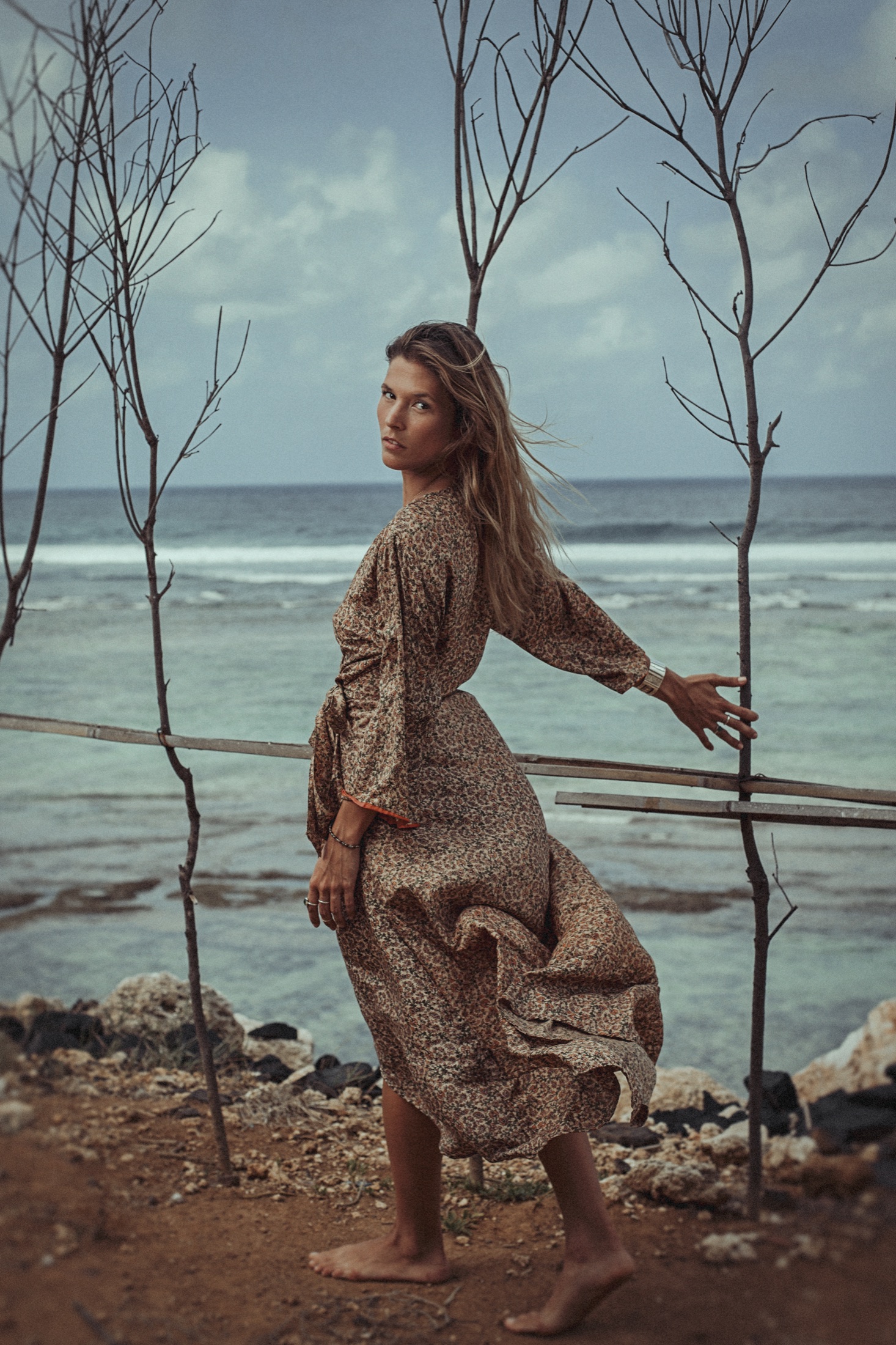 Frau im gemusterten Kleid am Meer auf Bali – Editorialportrait von Evgenia Huber