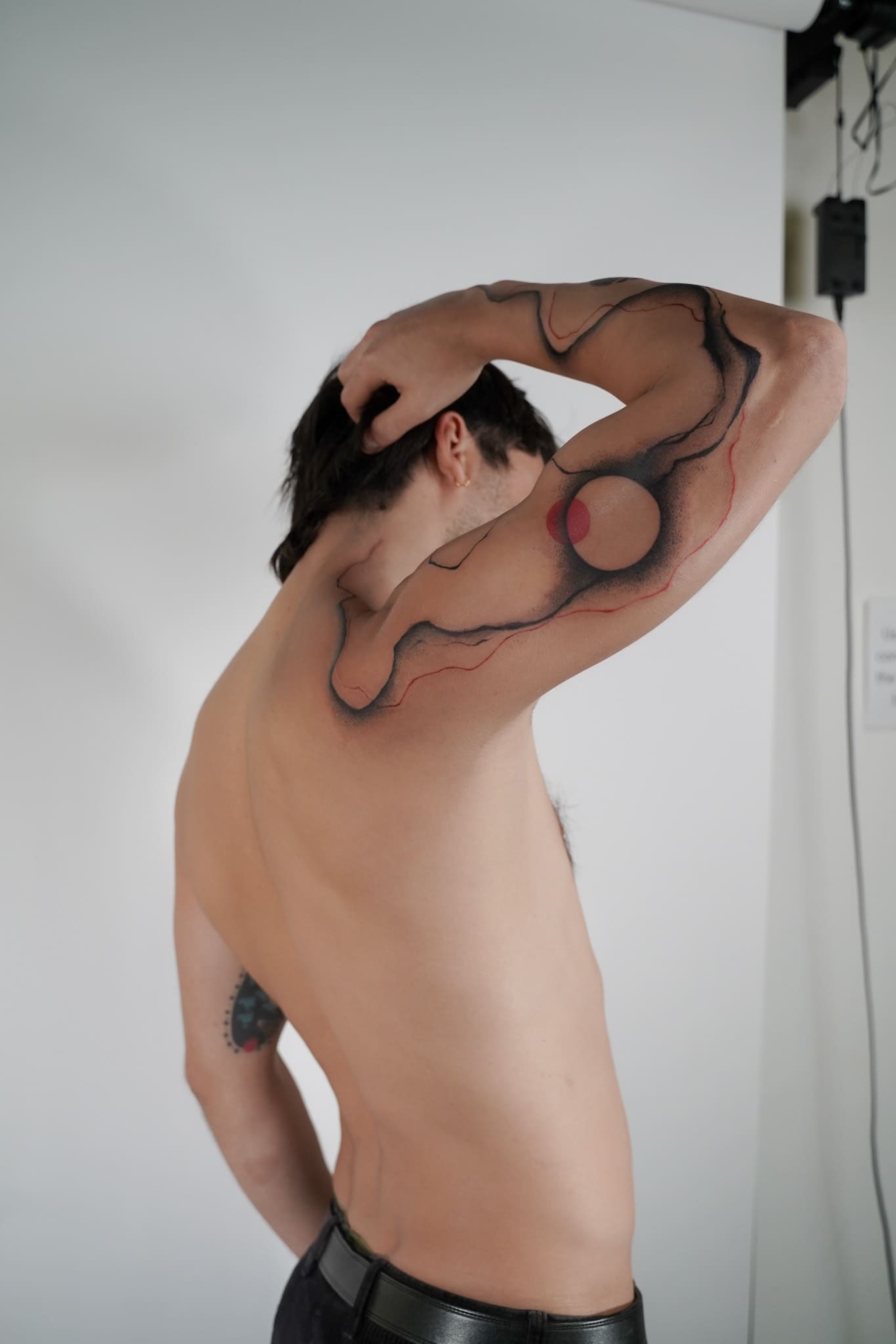 Organic lines with a red circle on the upper arm
