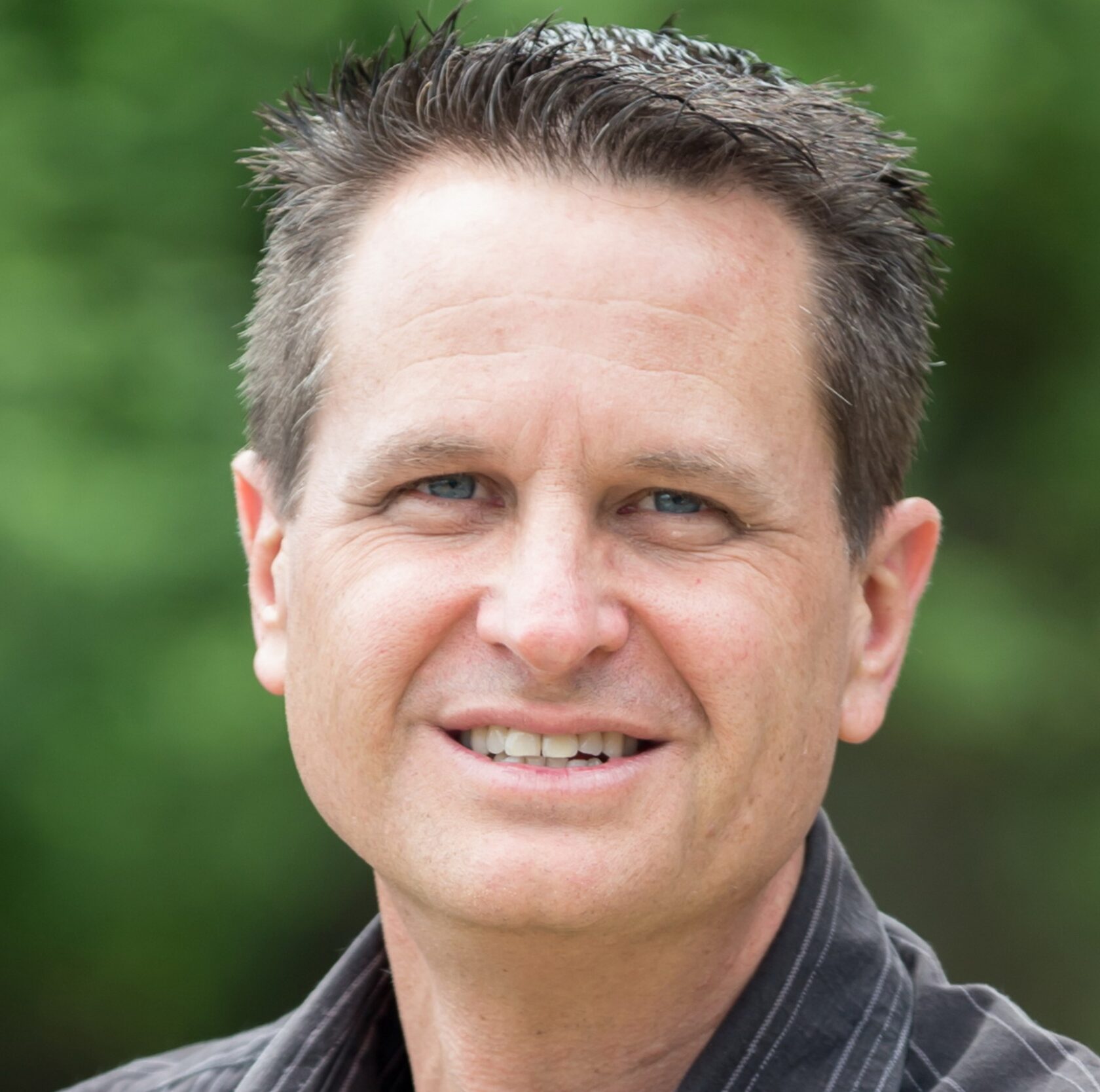 James Goren,A man wearing a black shirt smiles warmly at the camera, exuding a friendly and approachable demeanor