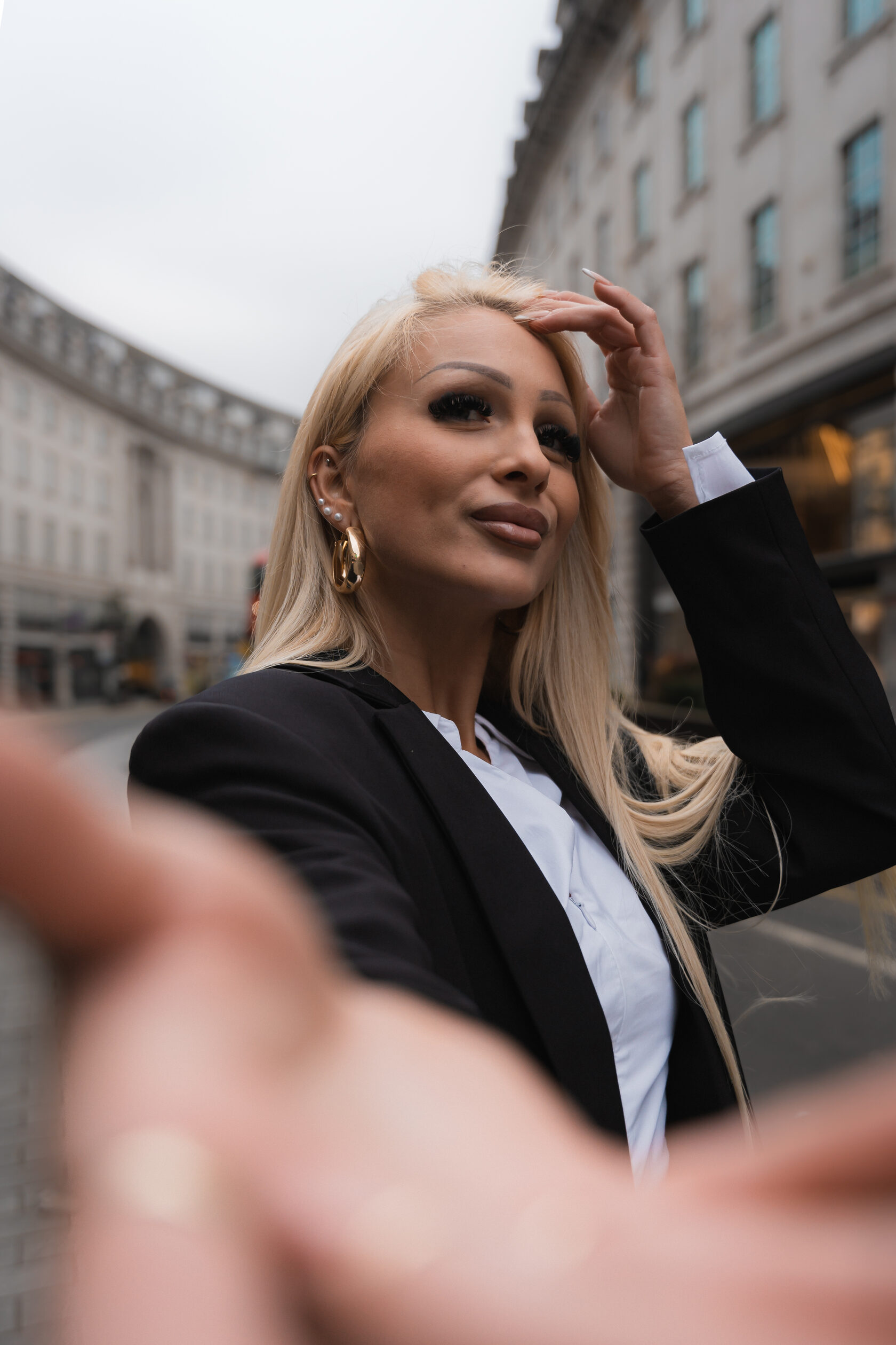 A woman reaching towards the camera on a London street