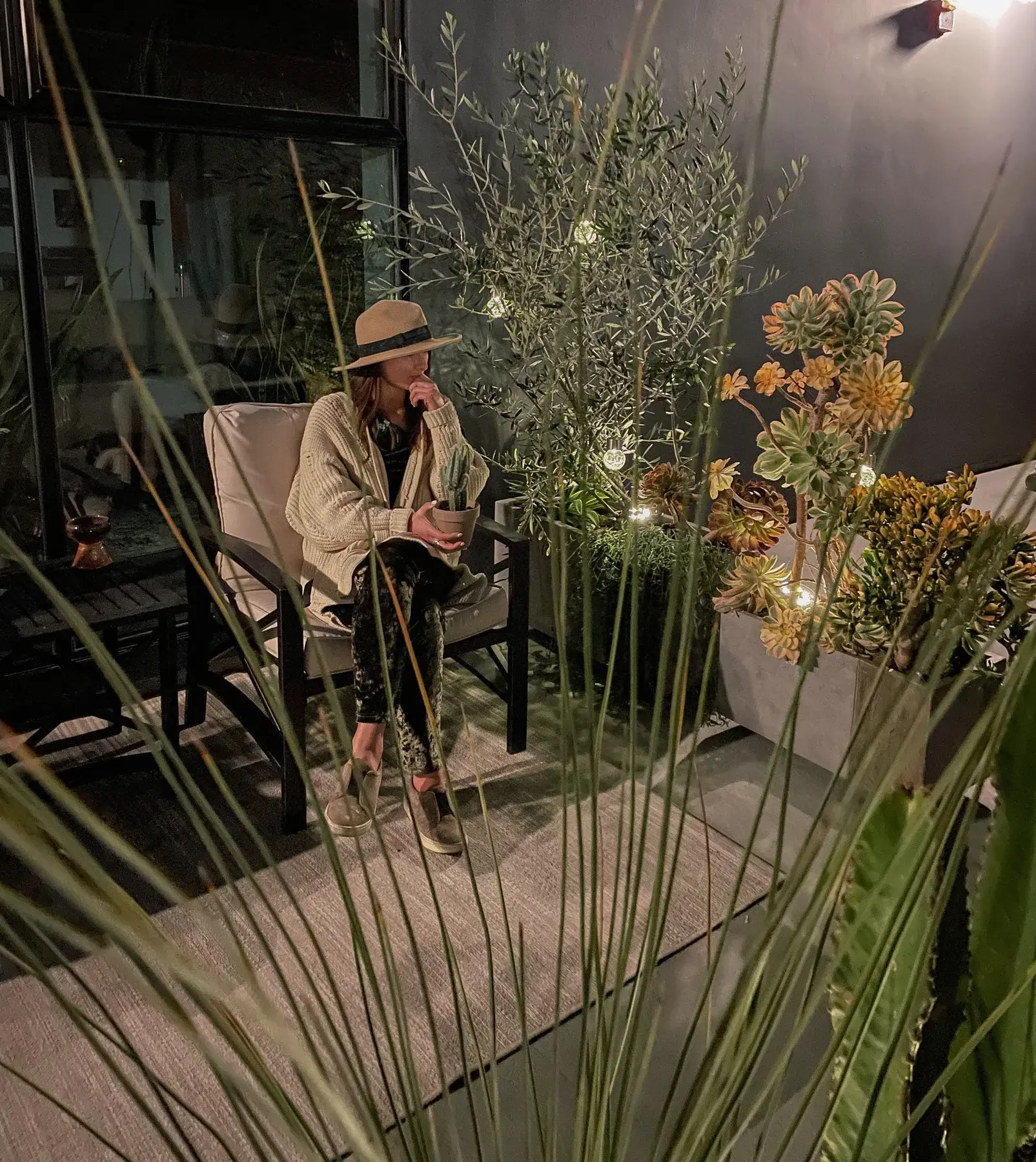 Katya among olive trees, cacti and succulents on the patio