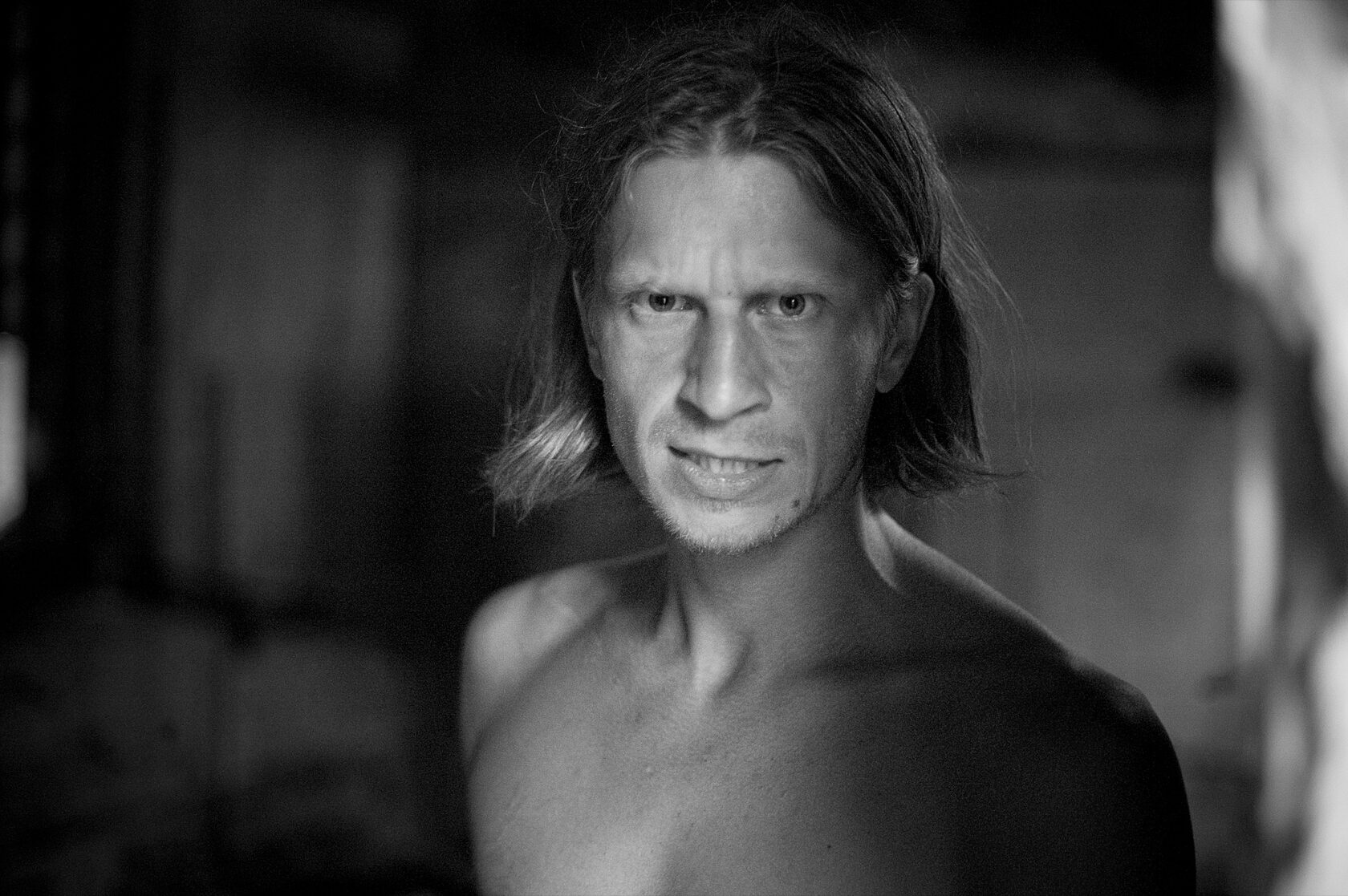 Schwarz-Weiß-Nahportrait eines Mannes mit schulterlangem Haar