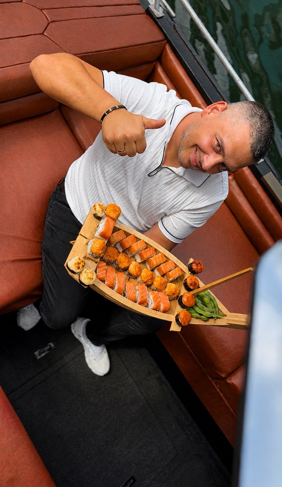 Guest holding a full sushi boat tray