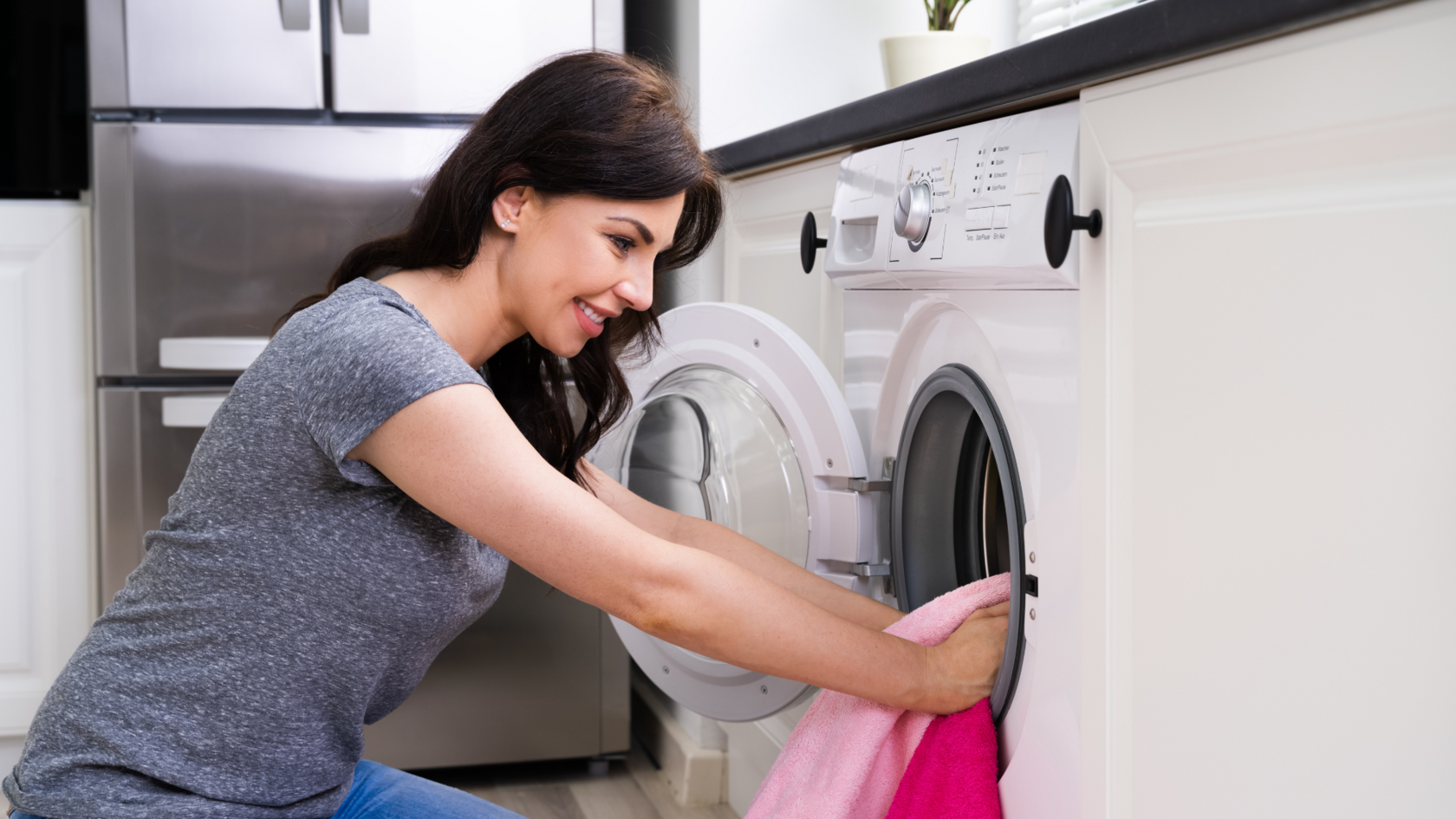 The image shows a woman loading laundry into a washing machine, highlighting how choosing the right water softener for an apartment or house helps protect fabrics and appliances from hard water damage