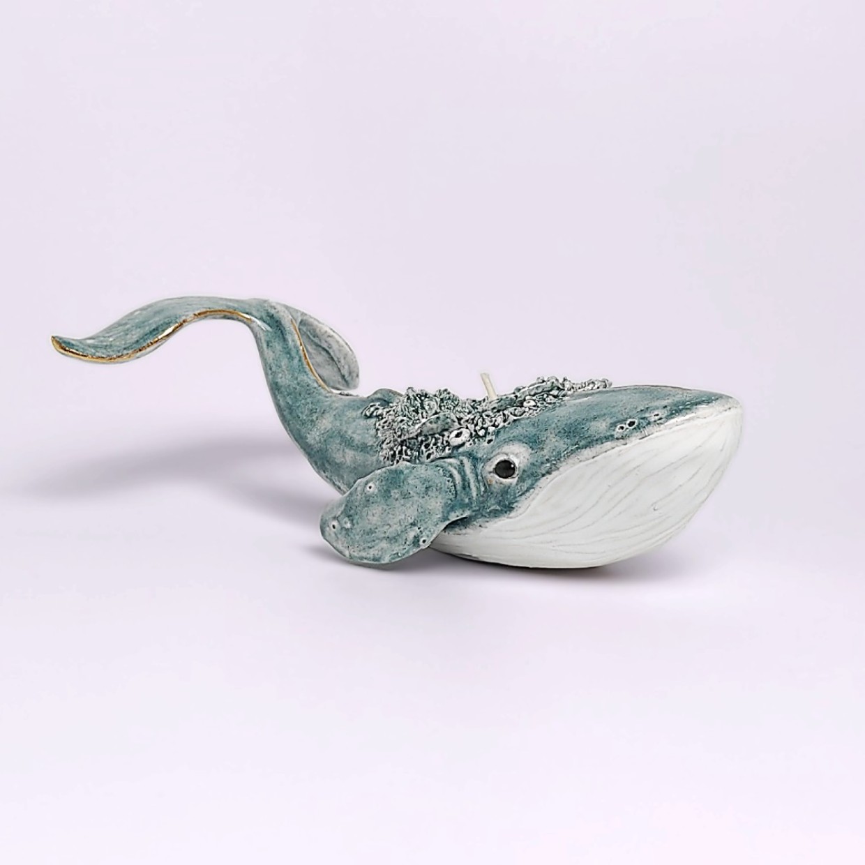 Unique handmade lagoon-colored ceramic whale with detailed sculptural texture and a built-in candle, inspired by ocean forms