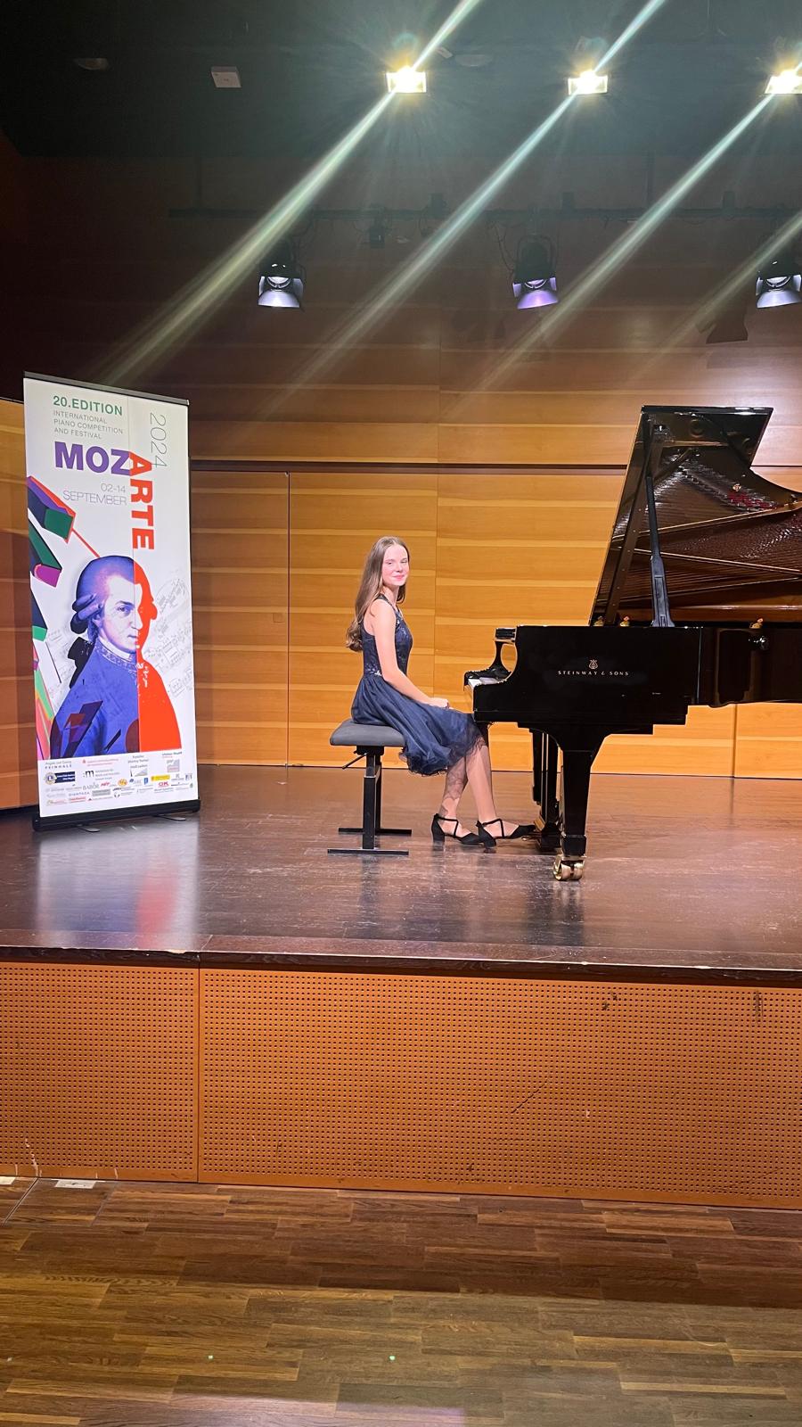Eine Schülerin des Musikateliers am Konzertflügel auf einer Bühne