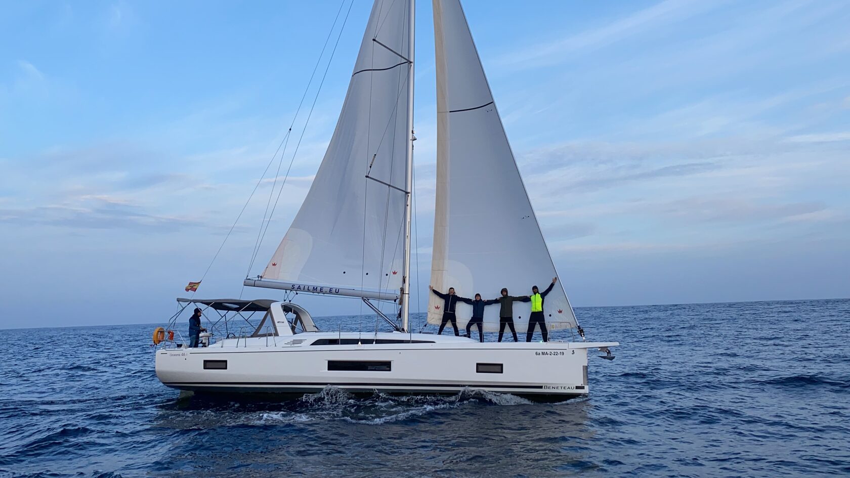 Guests on the bow of a yacht under full sail