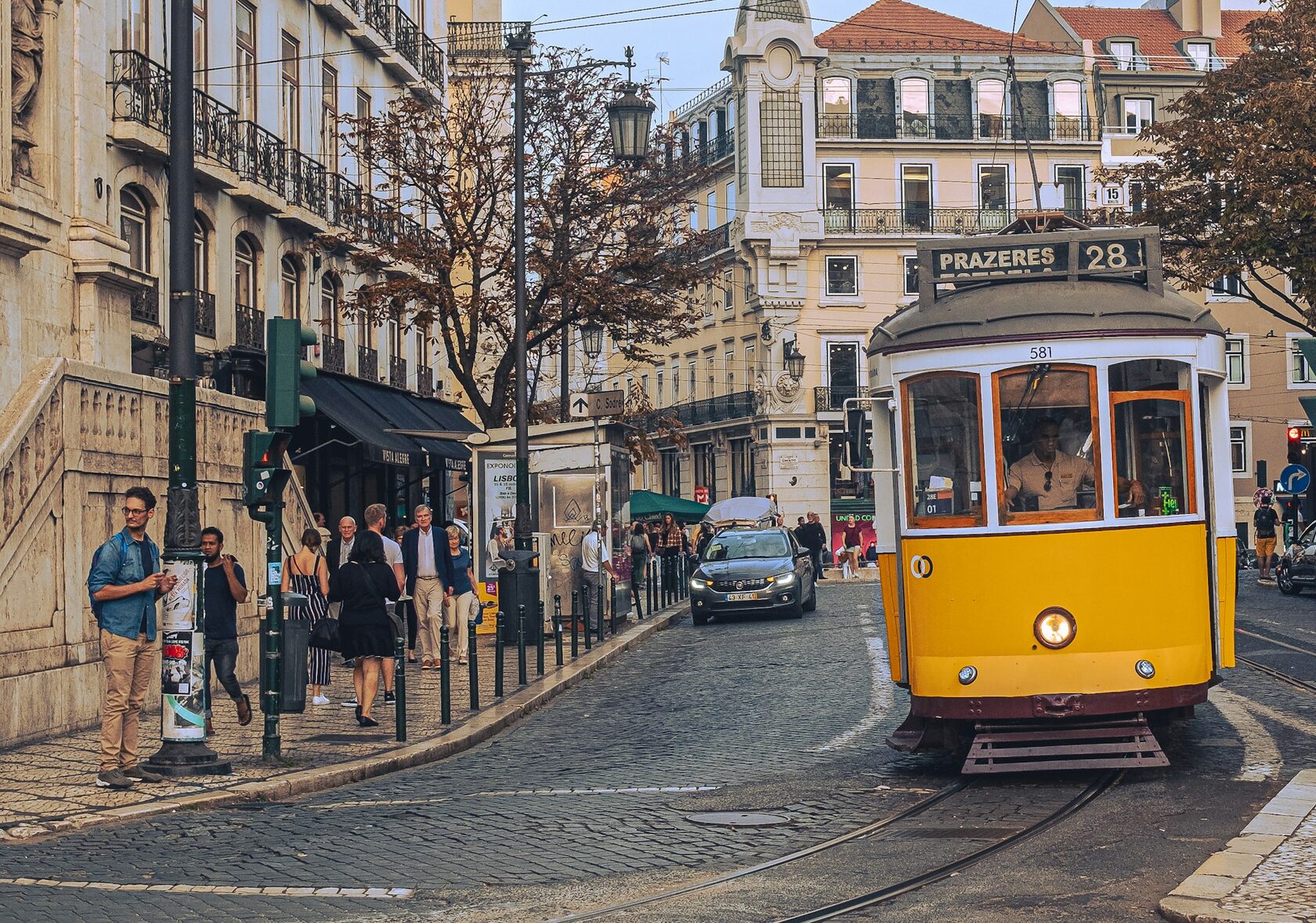Yellow tram on a tiled street in Lisbon