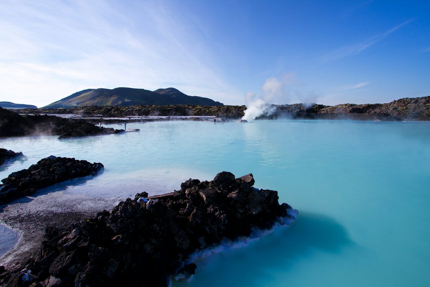 the Blue Lagoon in Iceland, milky turquoise geothermal water with rising steam and dark lava rocks