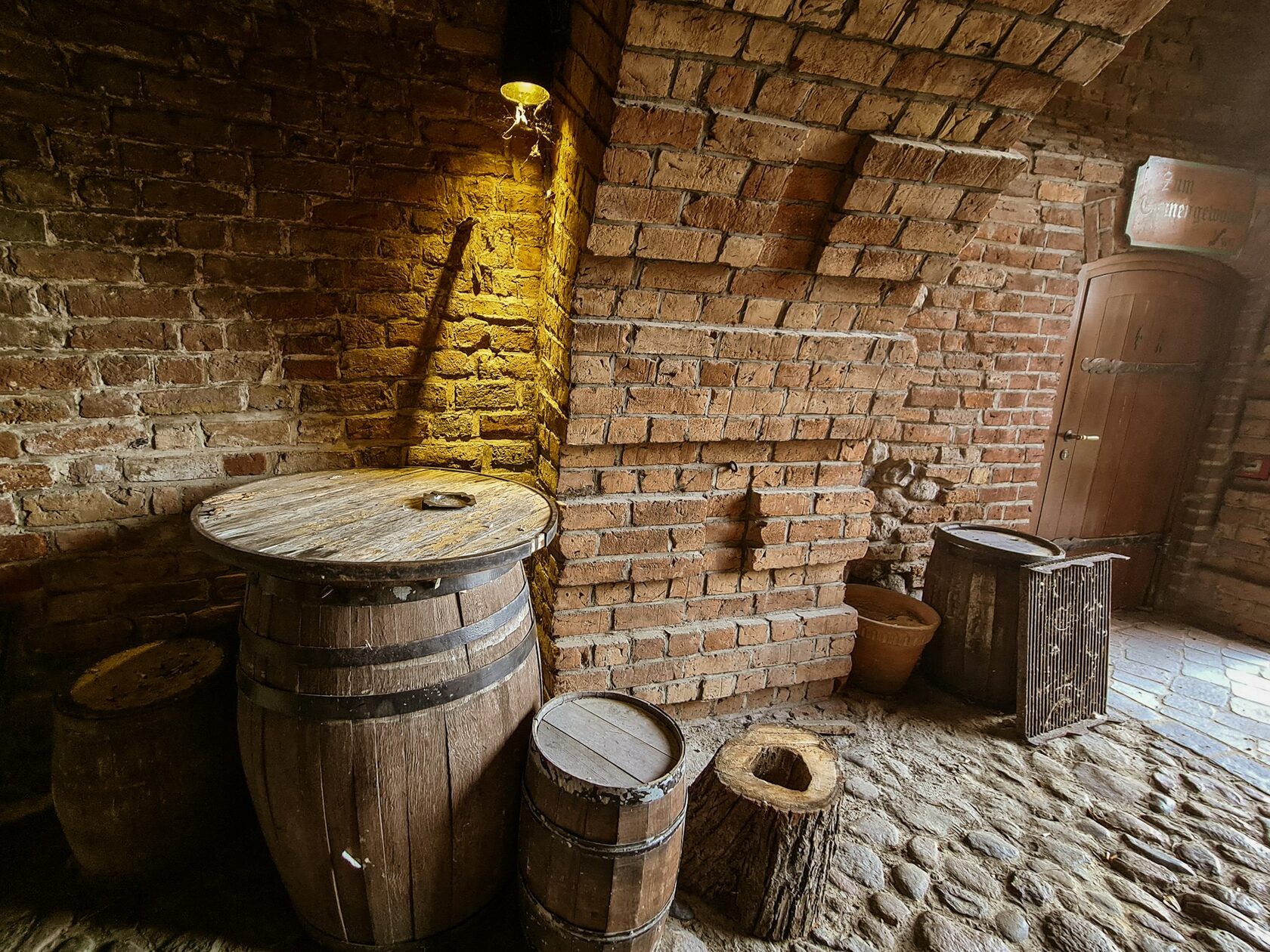 Candlelit wine cellar with stacked oak barrels