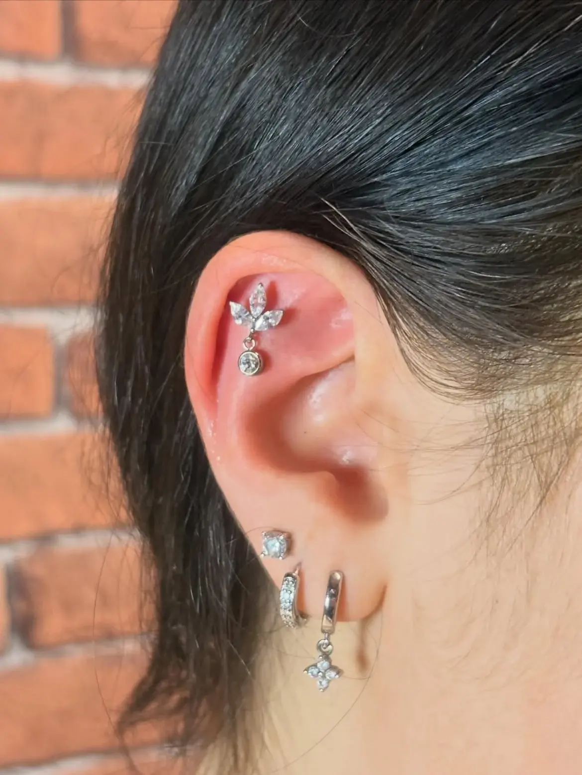 Piercing flat avec composition de bijoux argentés, réalisé au salon Ino-Ink