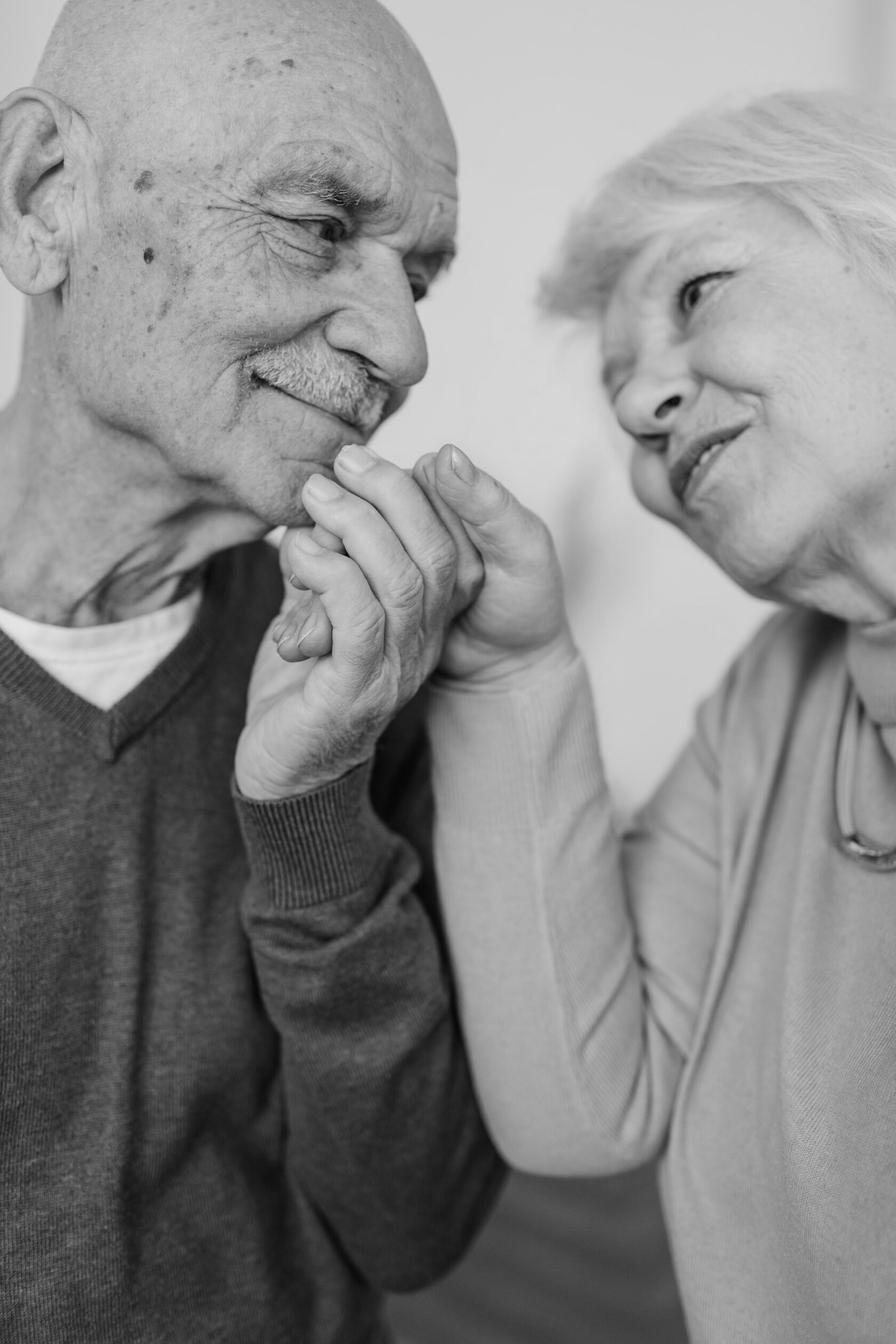 Älterer Mann und Frau halten sich an den Händen