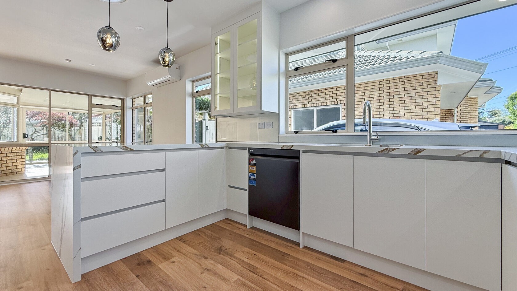 Updated St Heliers kitchen with new cabinetry, sink and timber-look flooring