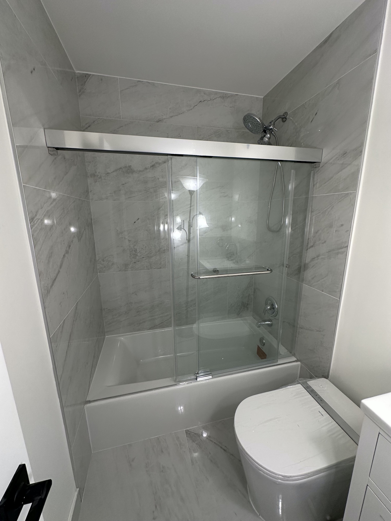 Smart toilet installed beside new acrylic tub in completed Austin bathroom remodel