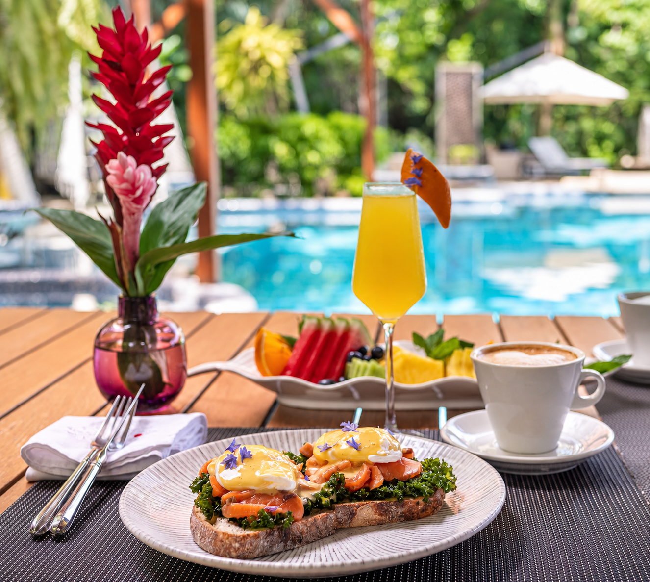 Breakfast served by the pool at Makanda, eggs Benedict, fruit and Costa Rican coffee