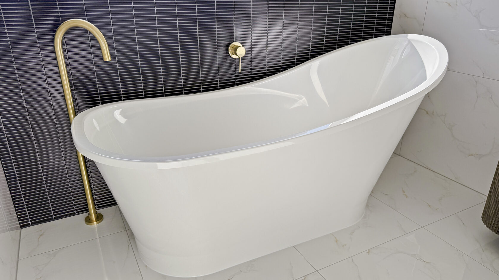 White freestanding bath with a brass floor-mounted tap and black tiled wall in St Heliers.