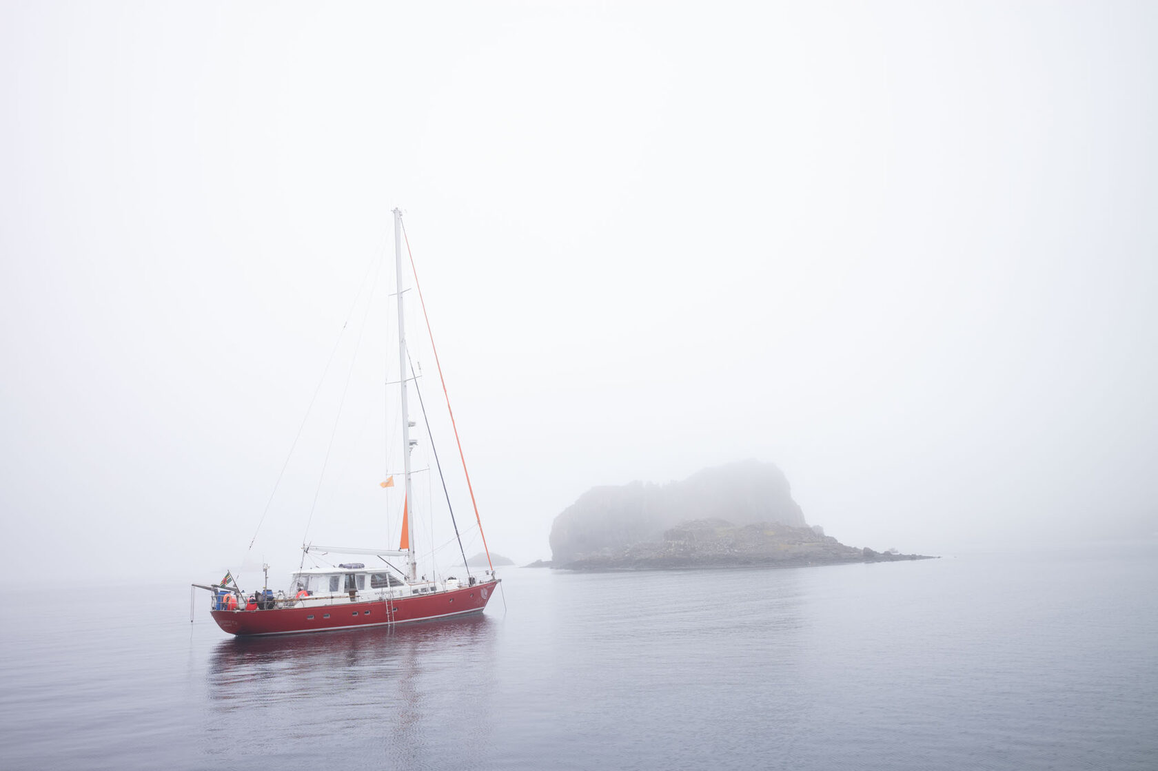 Red sailing yacht in Antarctic fog