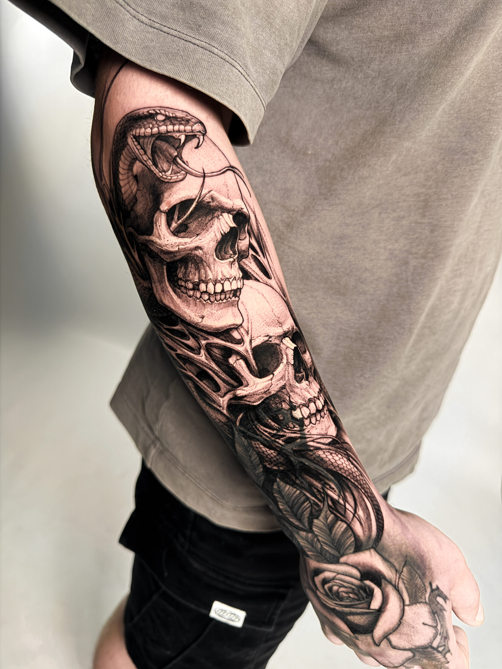 Black-and-Grey-Cover-Up mit Totenköpfen und Schlange am Unterarm