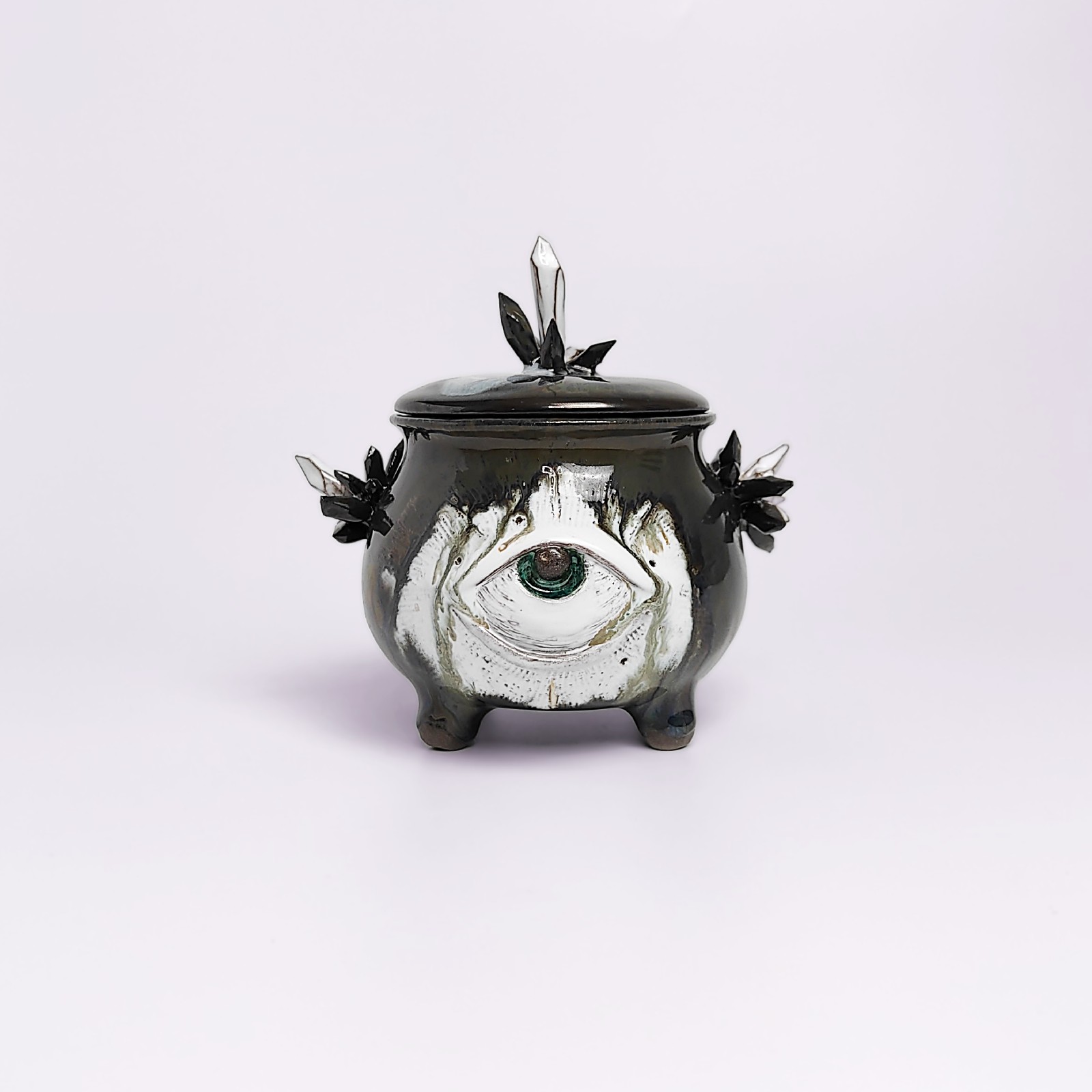 unique handmade ceramic witchy pot with a sculpted eye, black crystal accents, and a smoky dark glaze