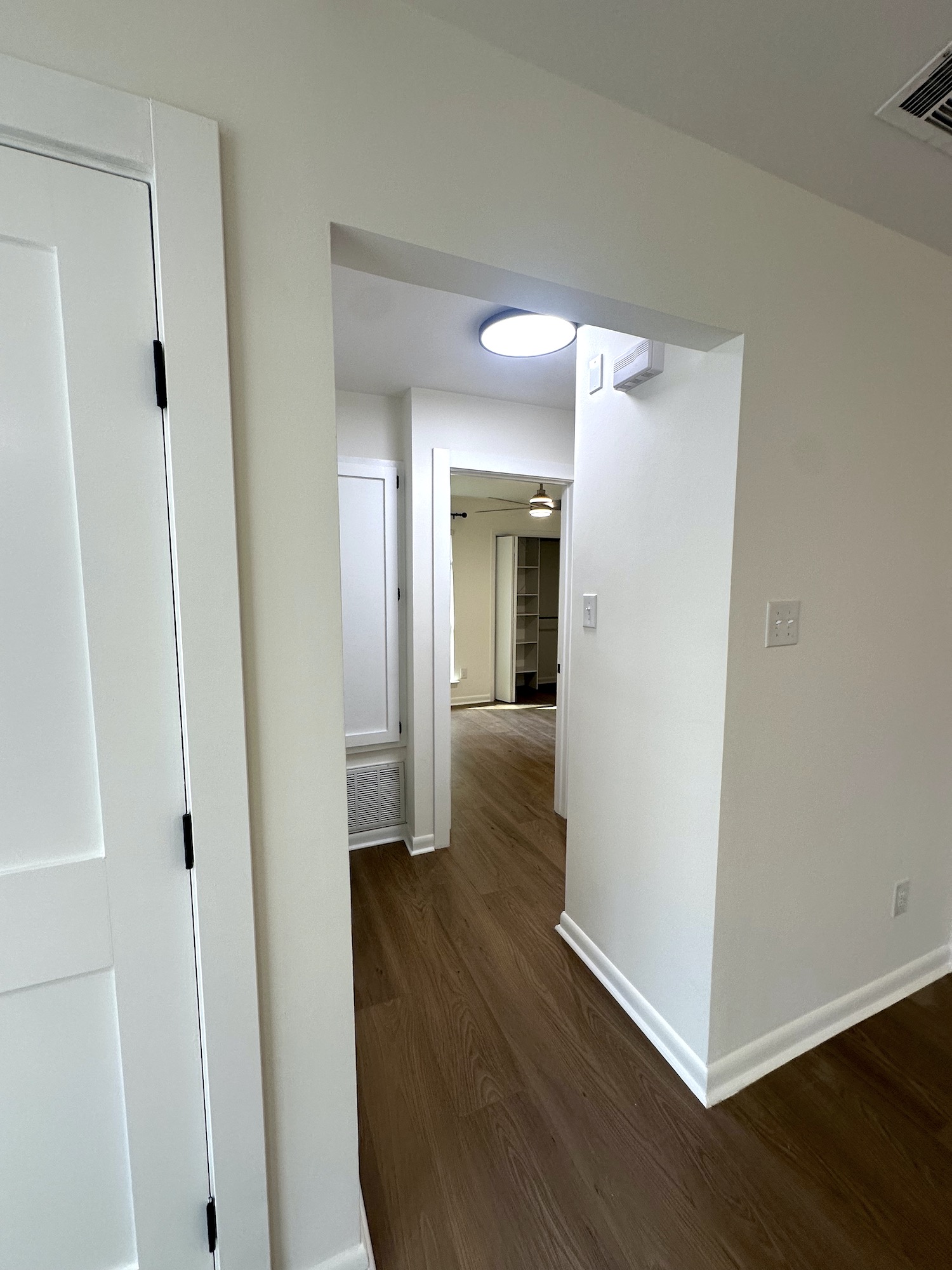 Renovated hallway showing smooth painted walls, finished openings and new flooring