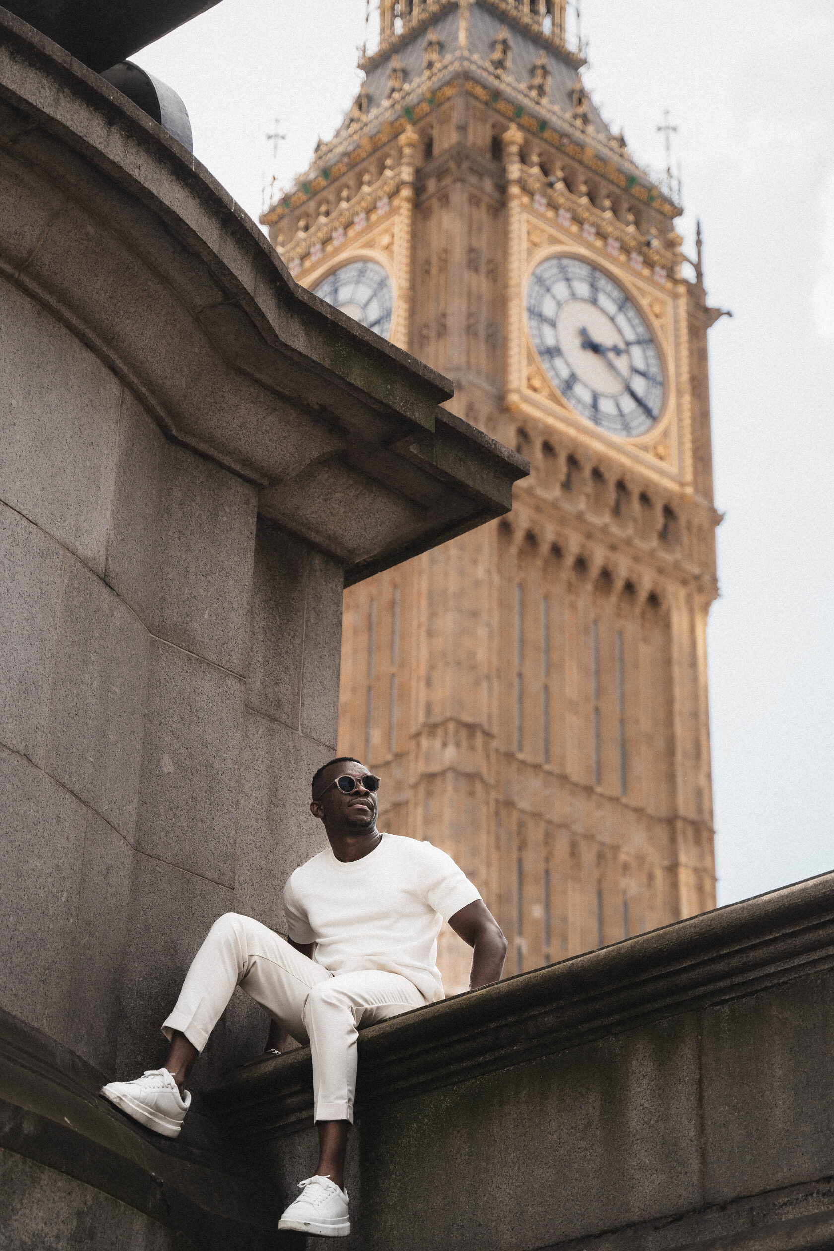 Seated portrait in a white suit beside Big Ben