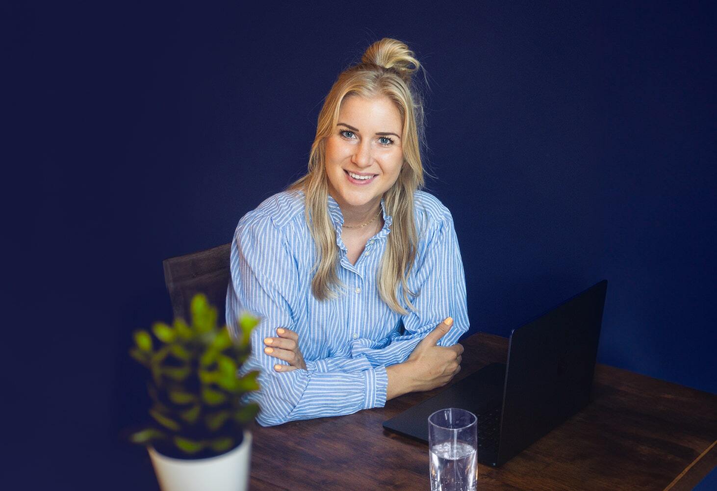 Femke Teunissen zit achter bureau achter laptop kijkt recht van voren