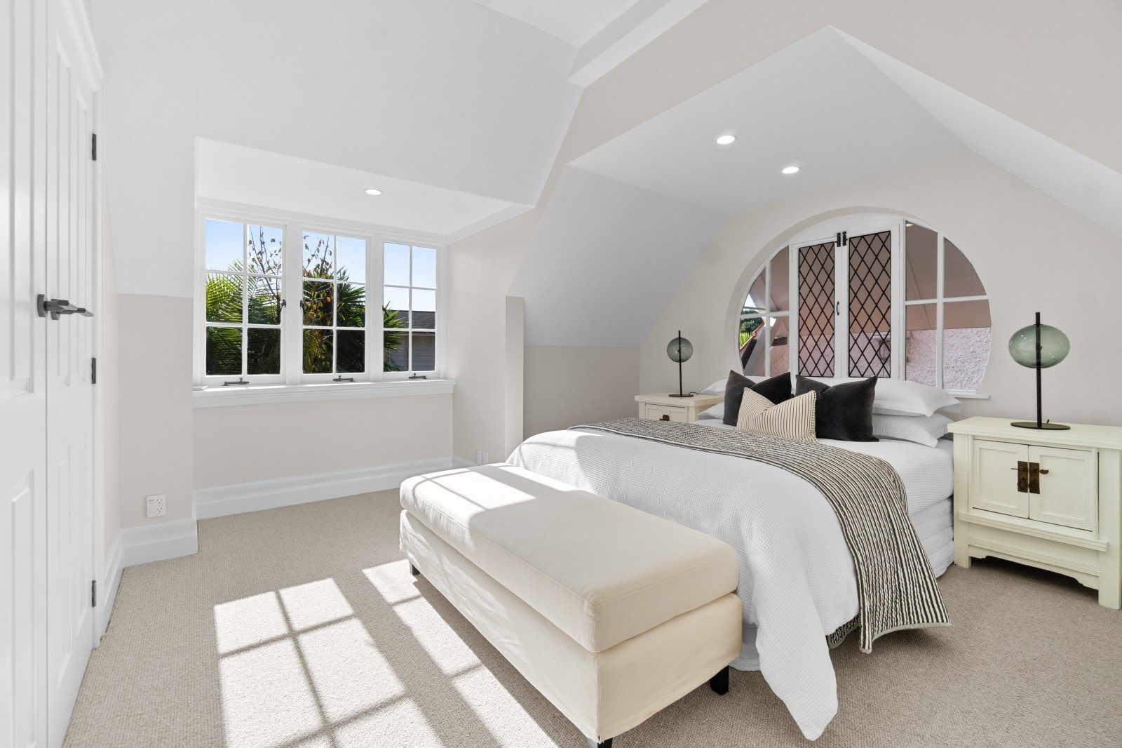Light-filled upstairs bedroom with a sloping ceiling and carpet in the Owens Road Epsom home