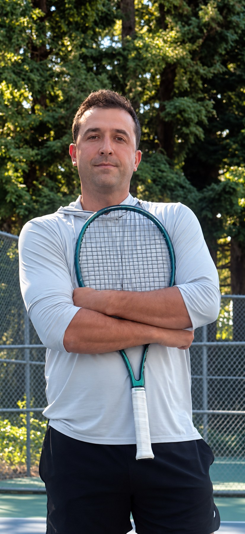 Coach Dmitriy holding a tennis racket on court