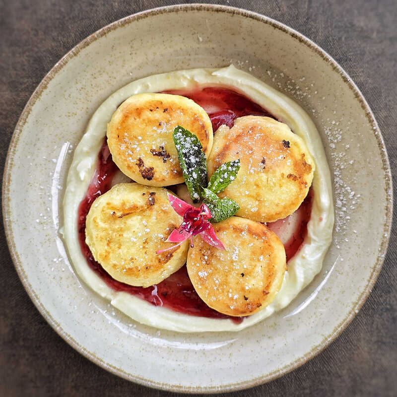 Homemade cheese pancake with mascarpone cream and lingonberry sauce