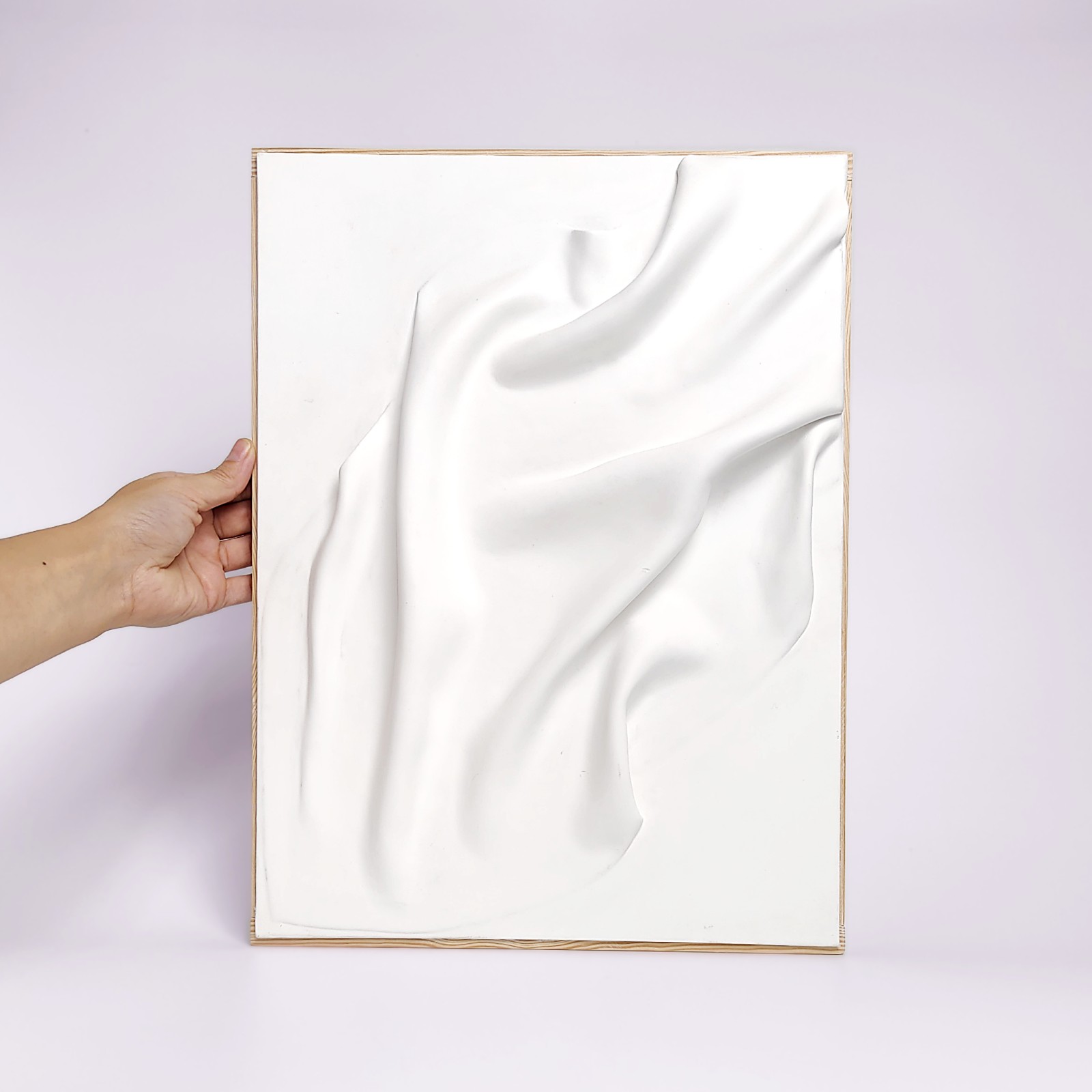 Unique handmade wall art crafted from air-dry clay, featuring minimalistic flowing sculptural drapery in a soft white finish