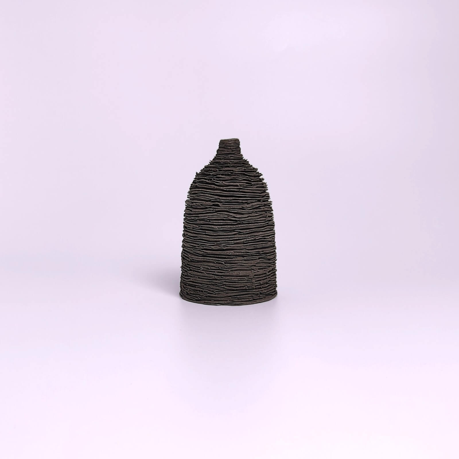 unique handmade black ceramic bud vase featuring a sculptural layered texture, minimalist modern decor for a single flower