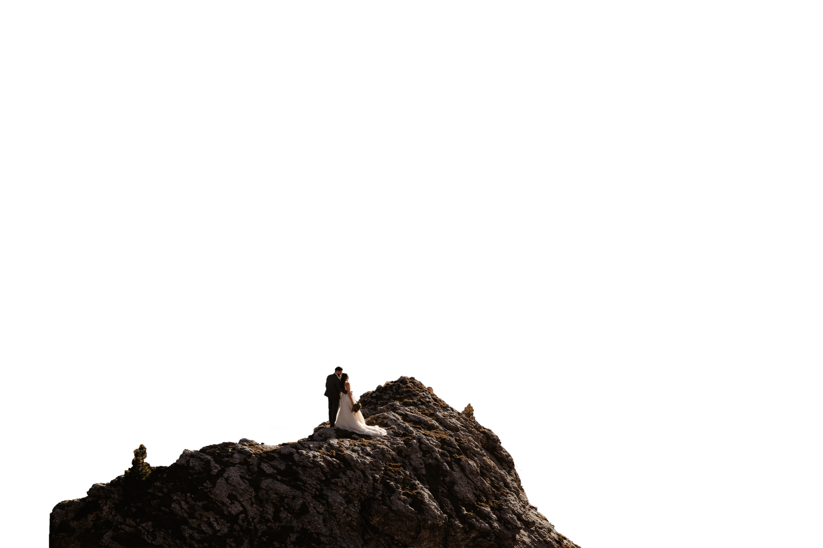 Couple embracing on a misty mountain summit at sunrise — authentic mountain elopement photography in European Alps