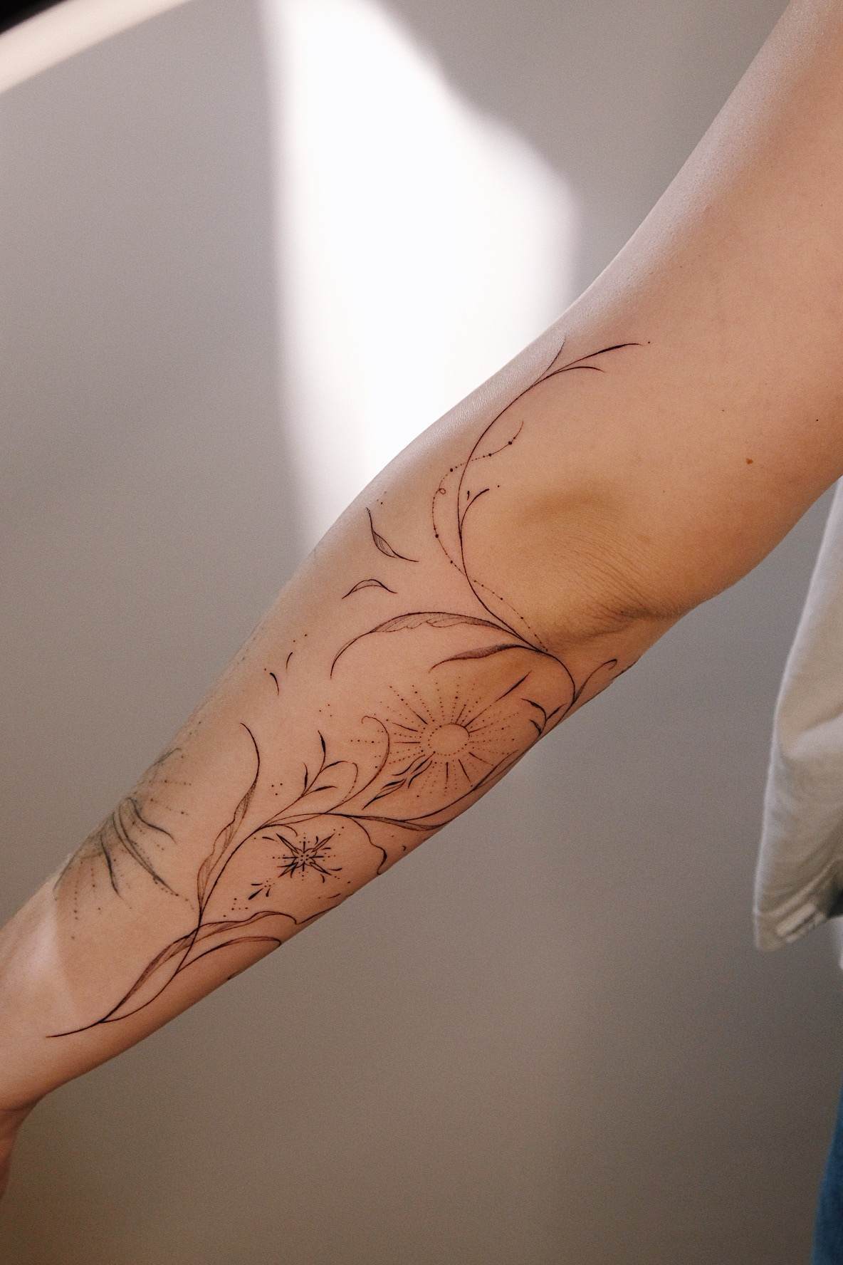 Botanische Linien und Blüten am Unterarm