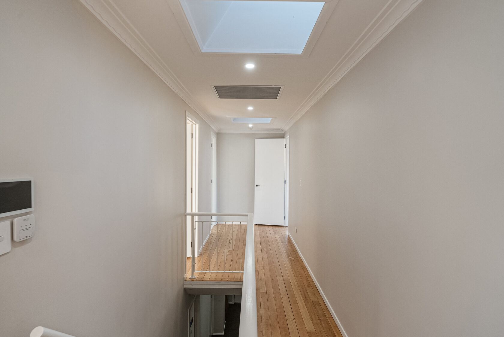Bright Glenfield hallway with timber flooring and recessed ceiling lights