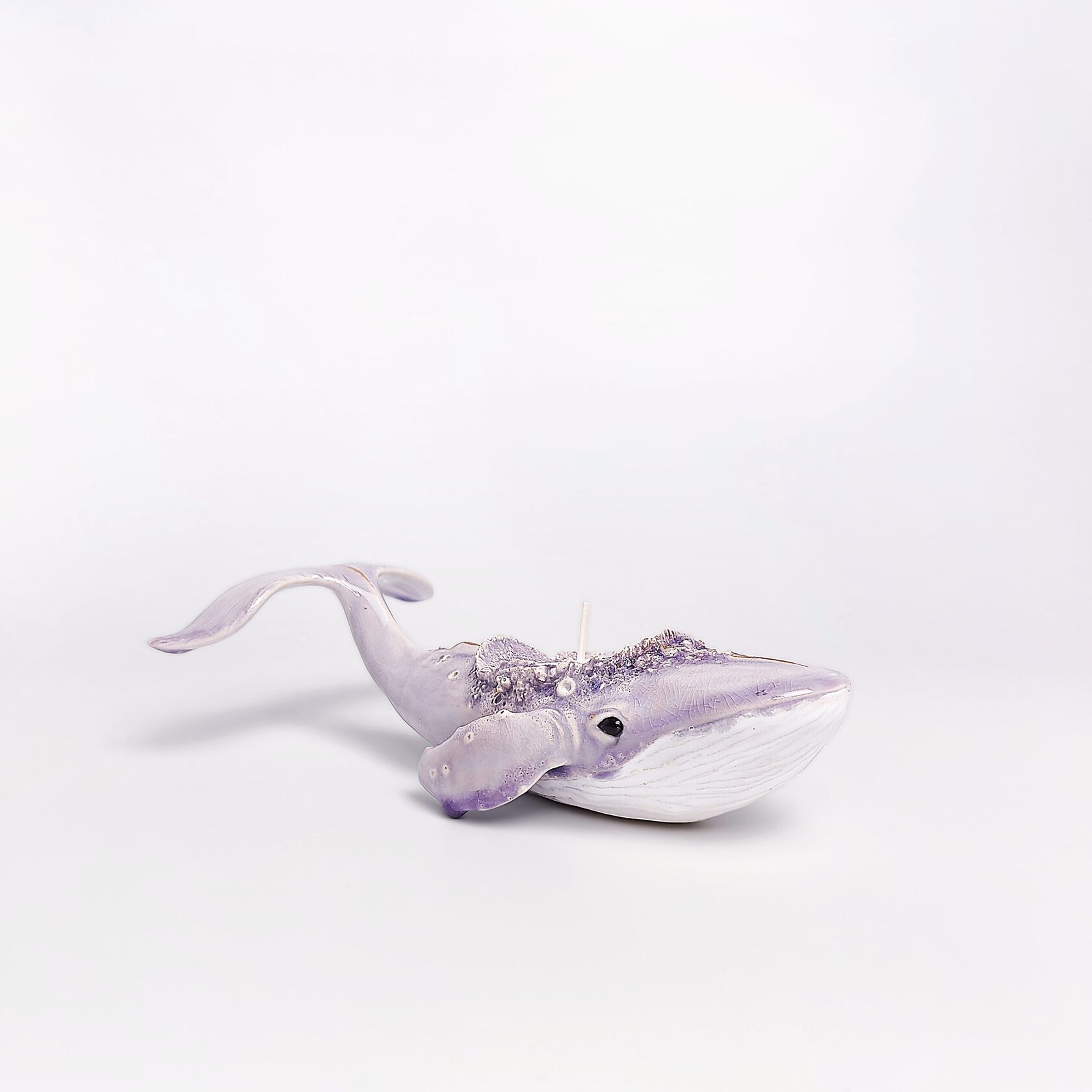 handmade ceramic candle holder shaped like a purple whale with sculptural details