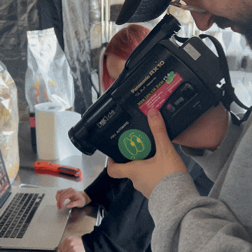 A camcorder pointed at a laptop and yellow mushrooms