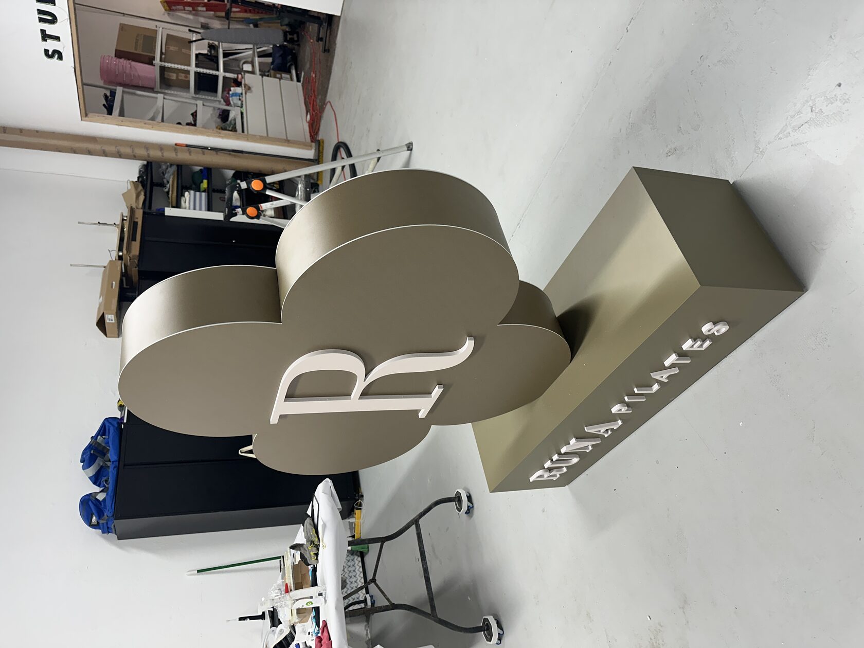 Side view of dimensional RUNA Pilates PVC logo with printed brand-color finish