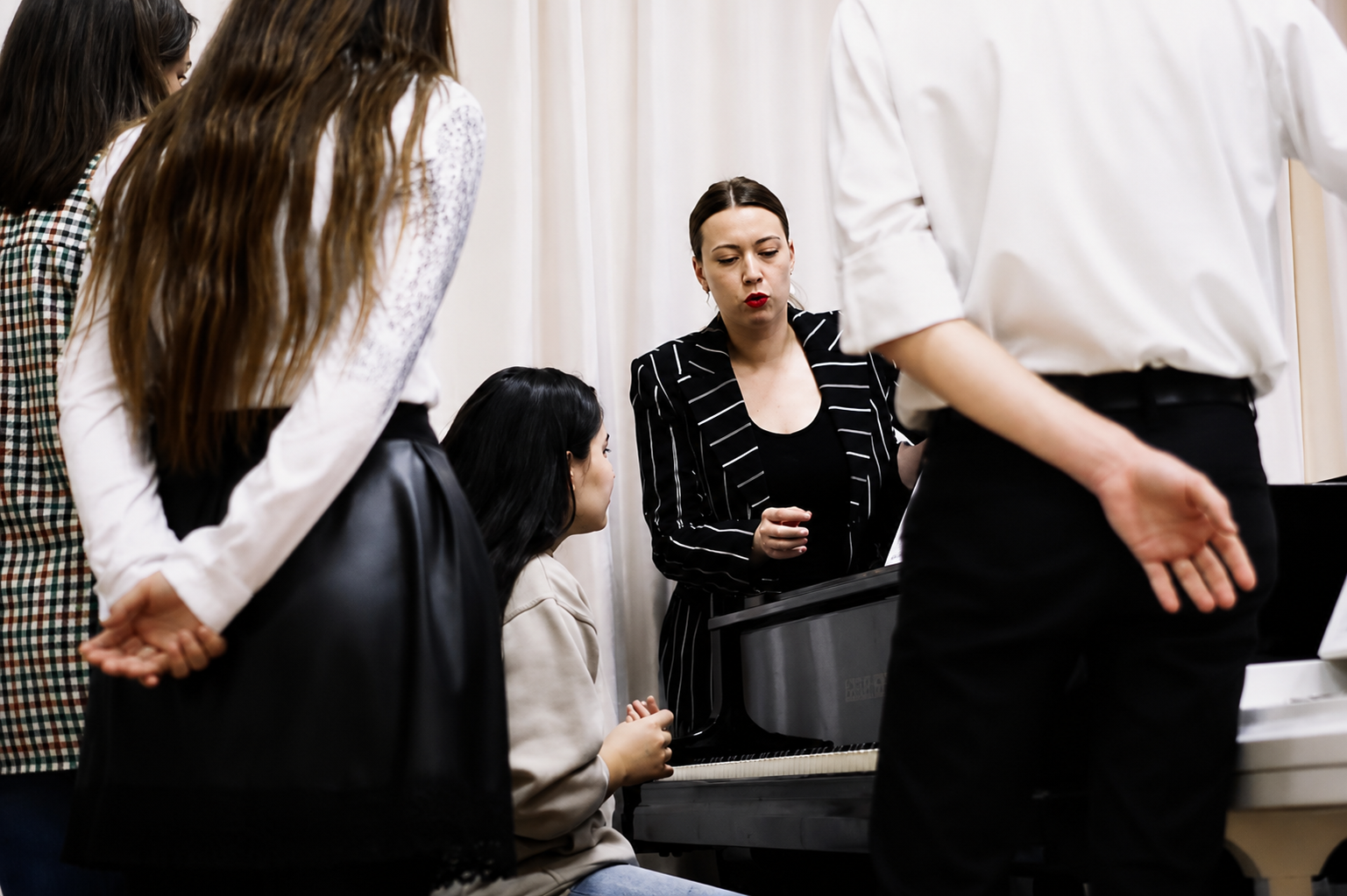 Diana Zuieva working with a small group of students at the piano