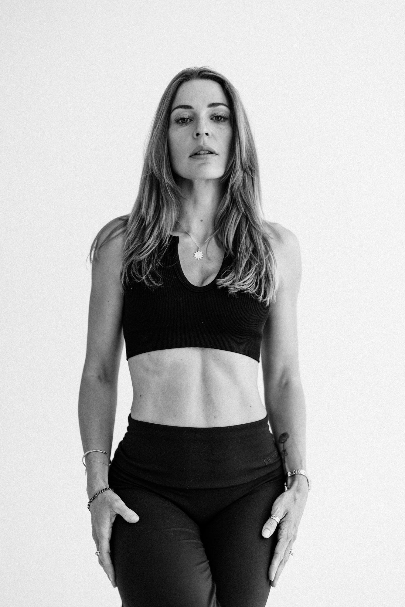 Schwarz-Weiß-Modelporträt in schwarzem Crop-Top und schwarzer Hose