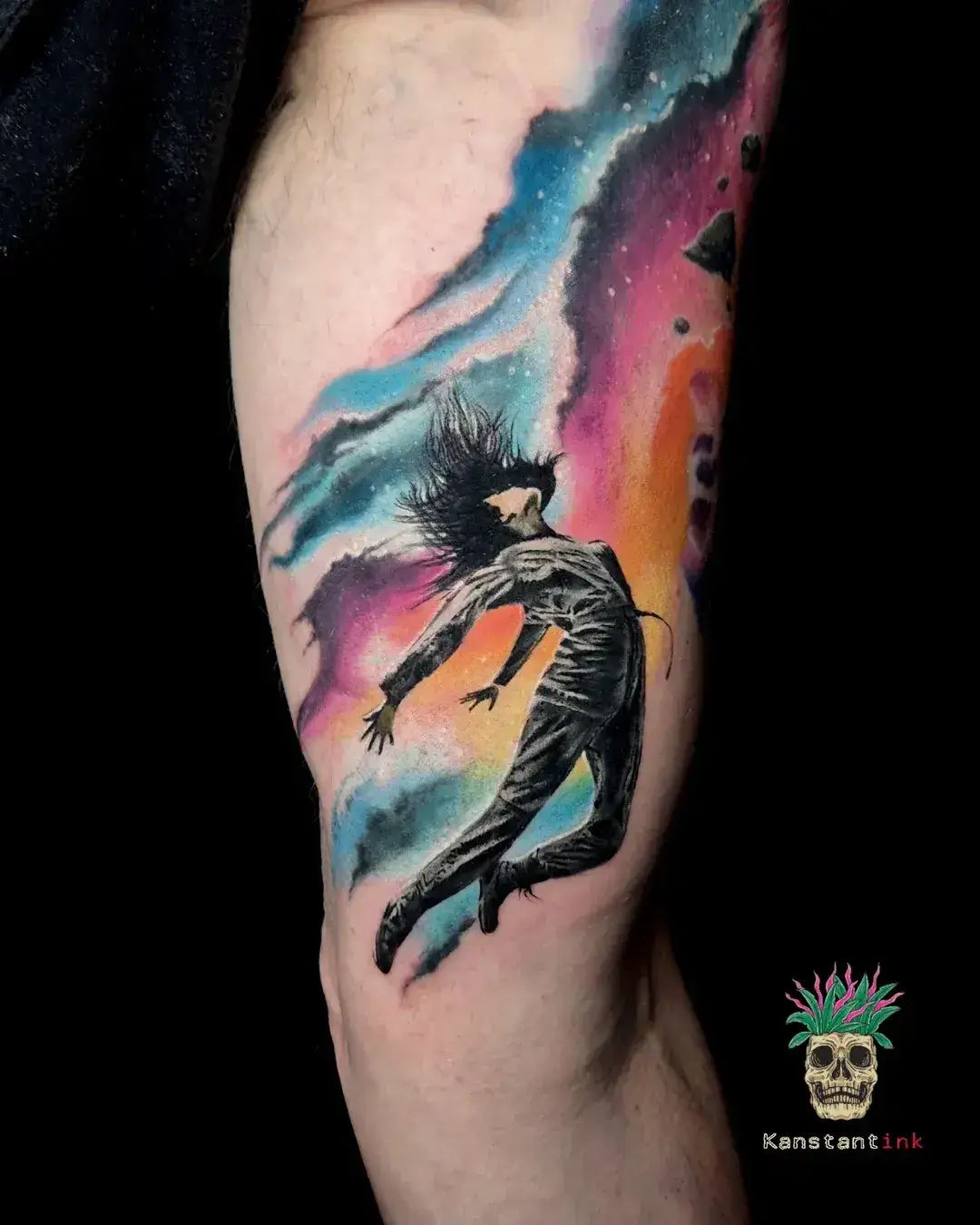 Dark figure against a colourful watercolour background