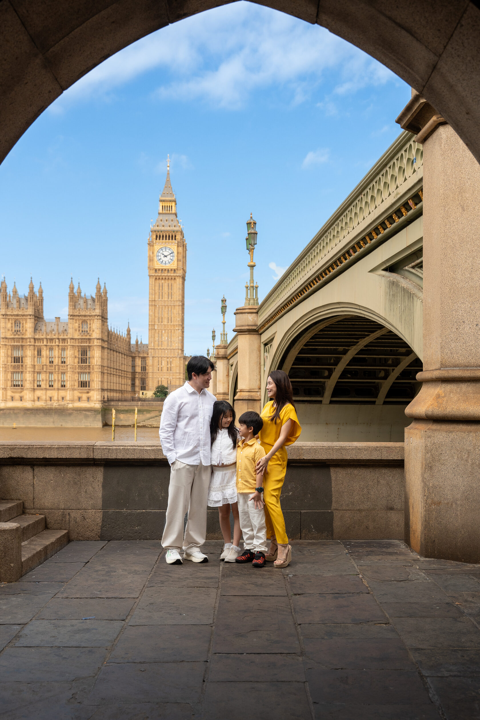 Family portrait framed by the arch beneath Westminster Bridge