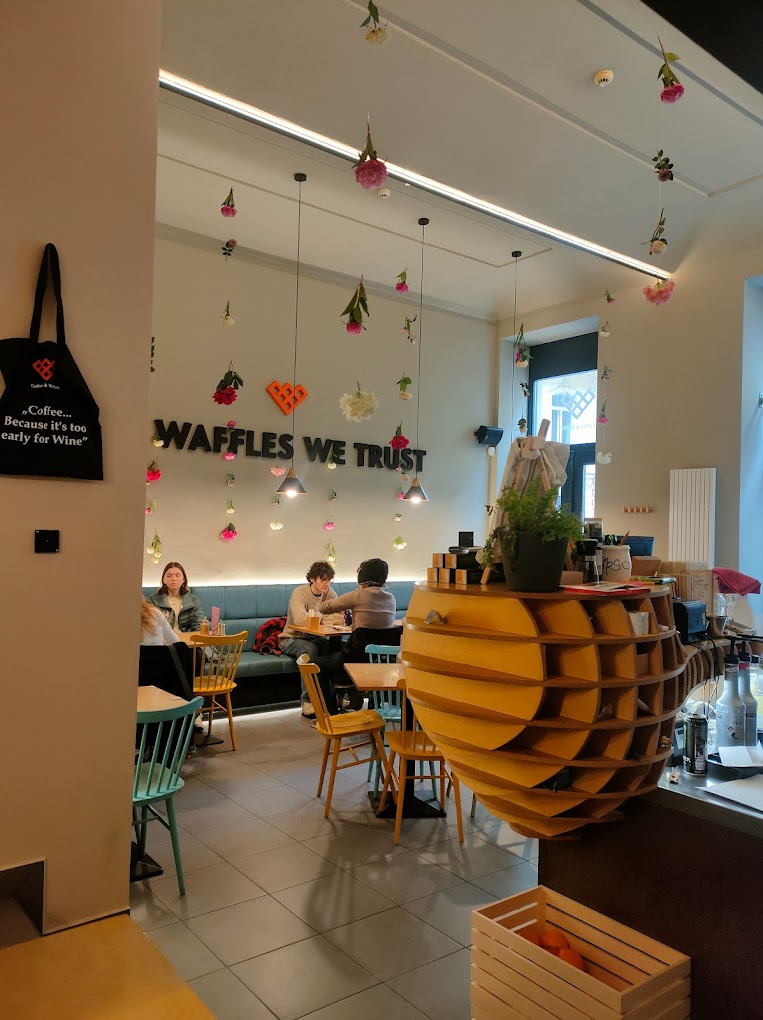 Interiér kavárny Coffee & Waffles s nápisem Waffles we trust
