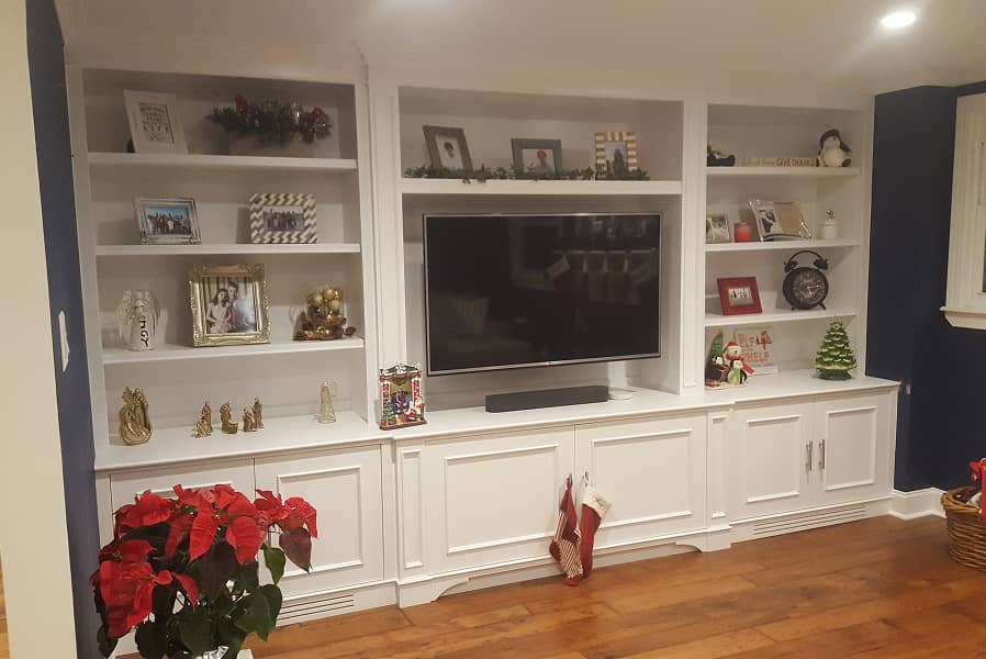 Family room entertainment center with lower cabinets and upper shelves.