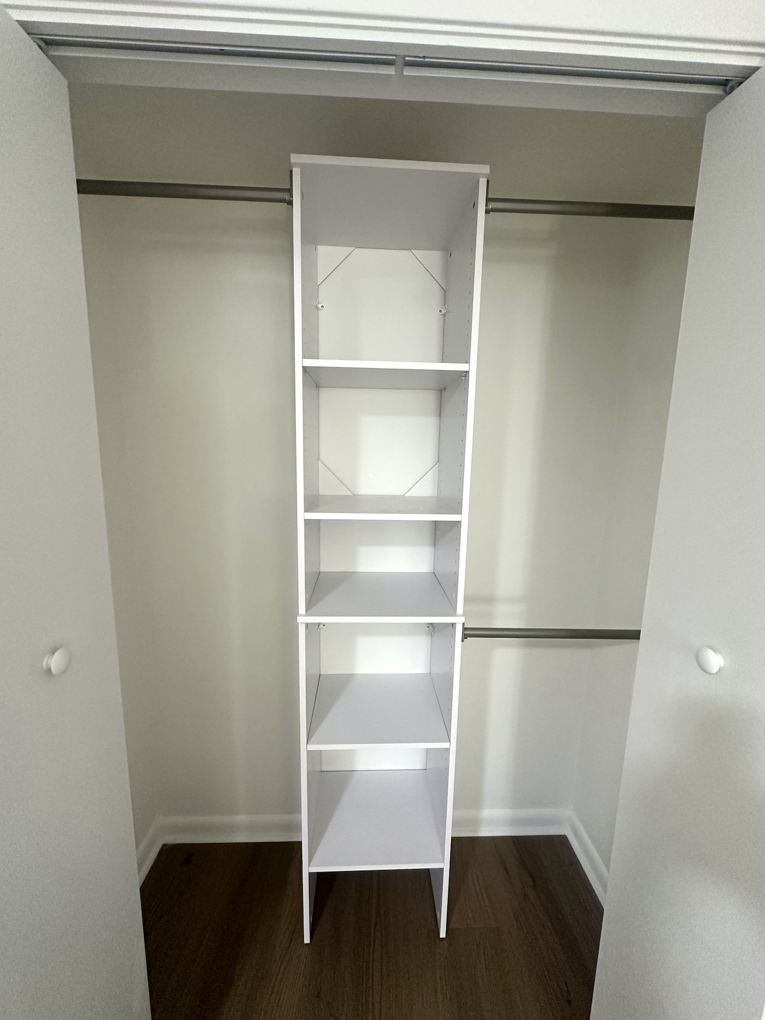 Installed closet organizer with shelving and hanging rods