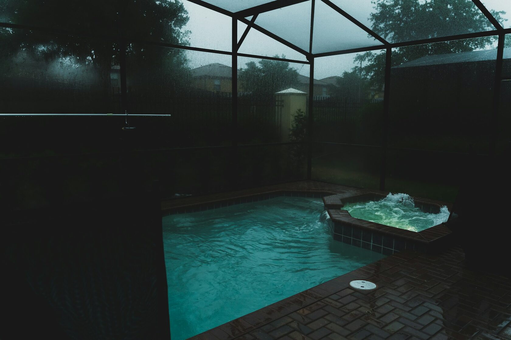 A single-story pool cage enclosing a backyard pool